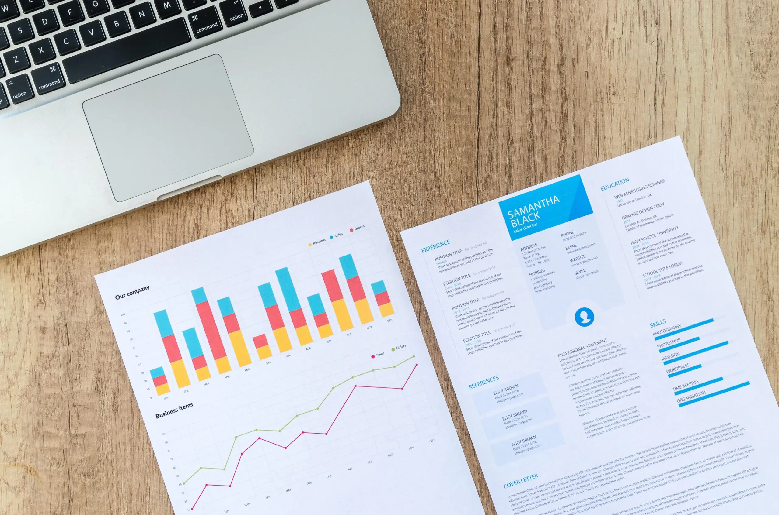 A picture of two sheets of paper on a table, one of graphs, and the other one a CV