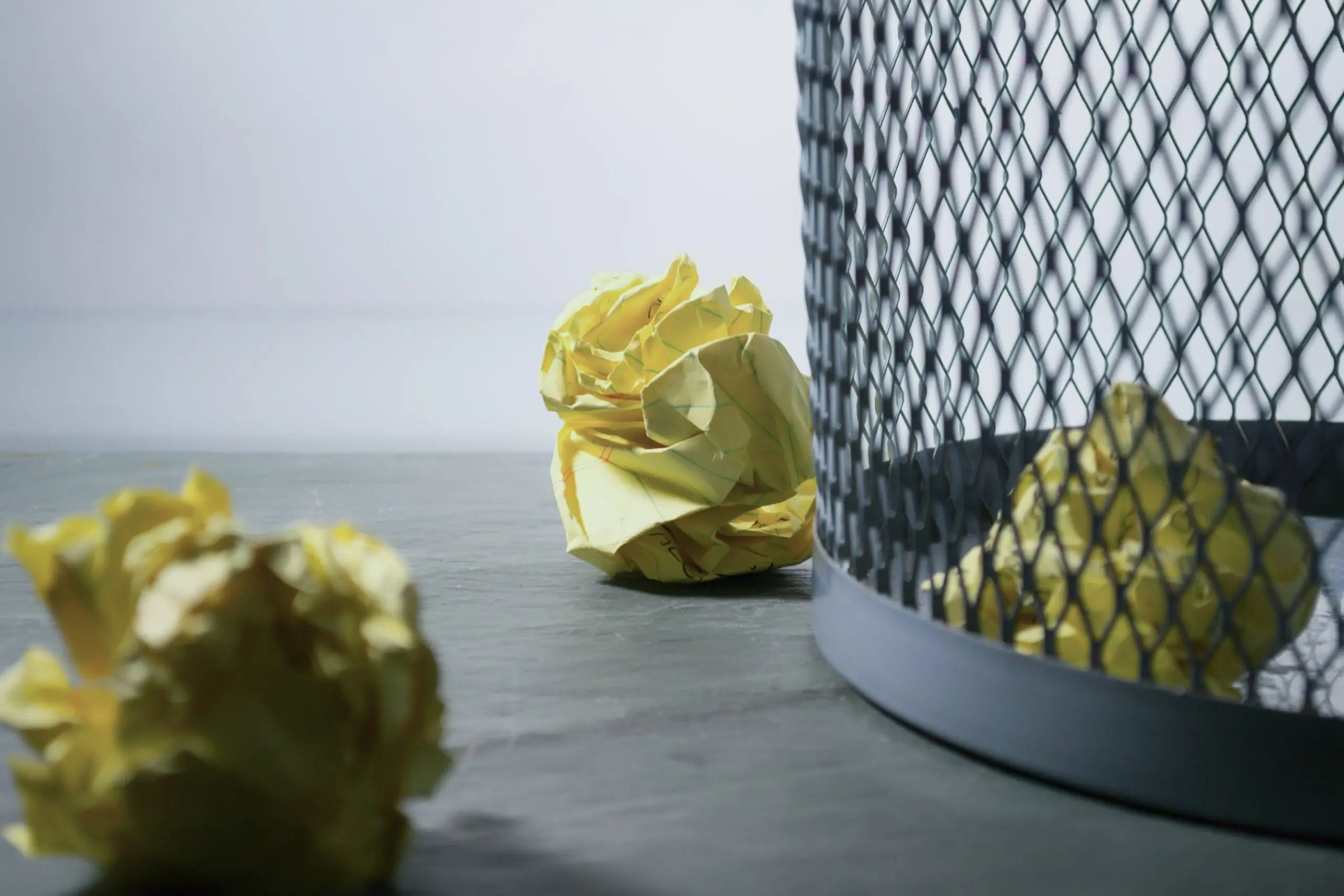 A wastebin, with three scrunched up bits of paper