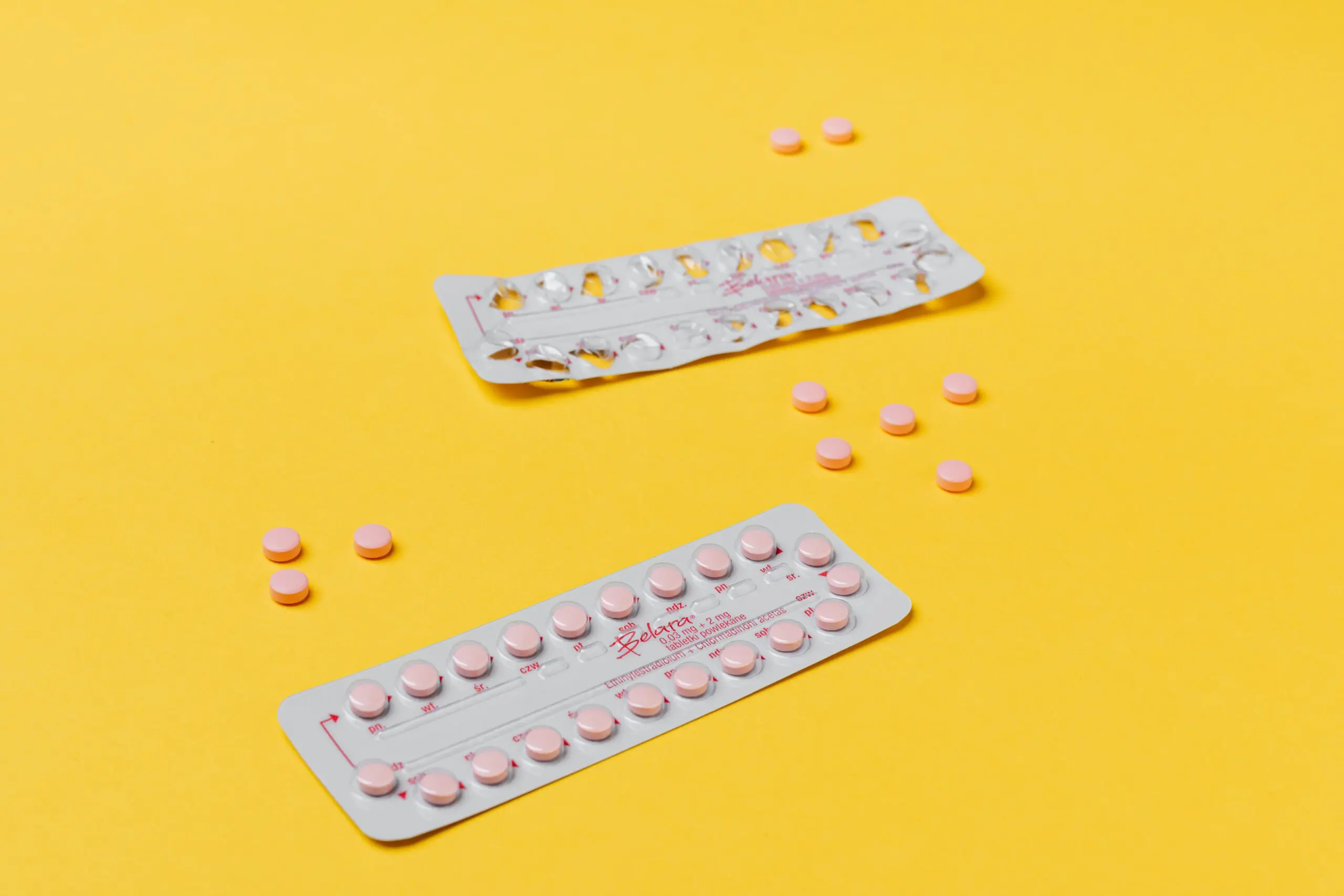 Two blisters of medication, one full, one emptied, with the pills scattered around