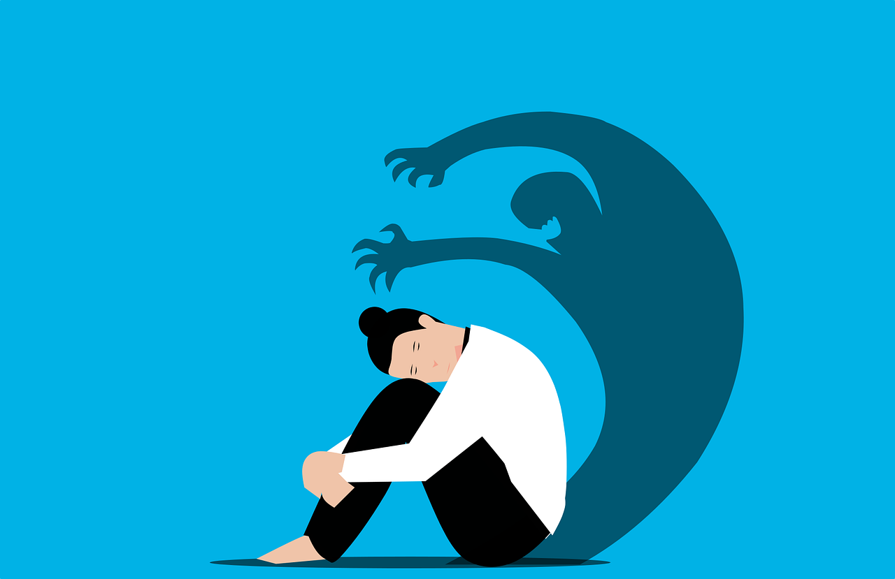 A stylised image of a person curled up, with their shadow raised against them