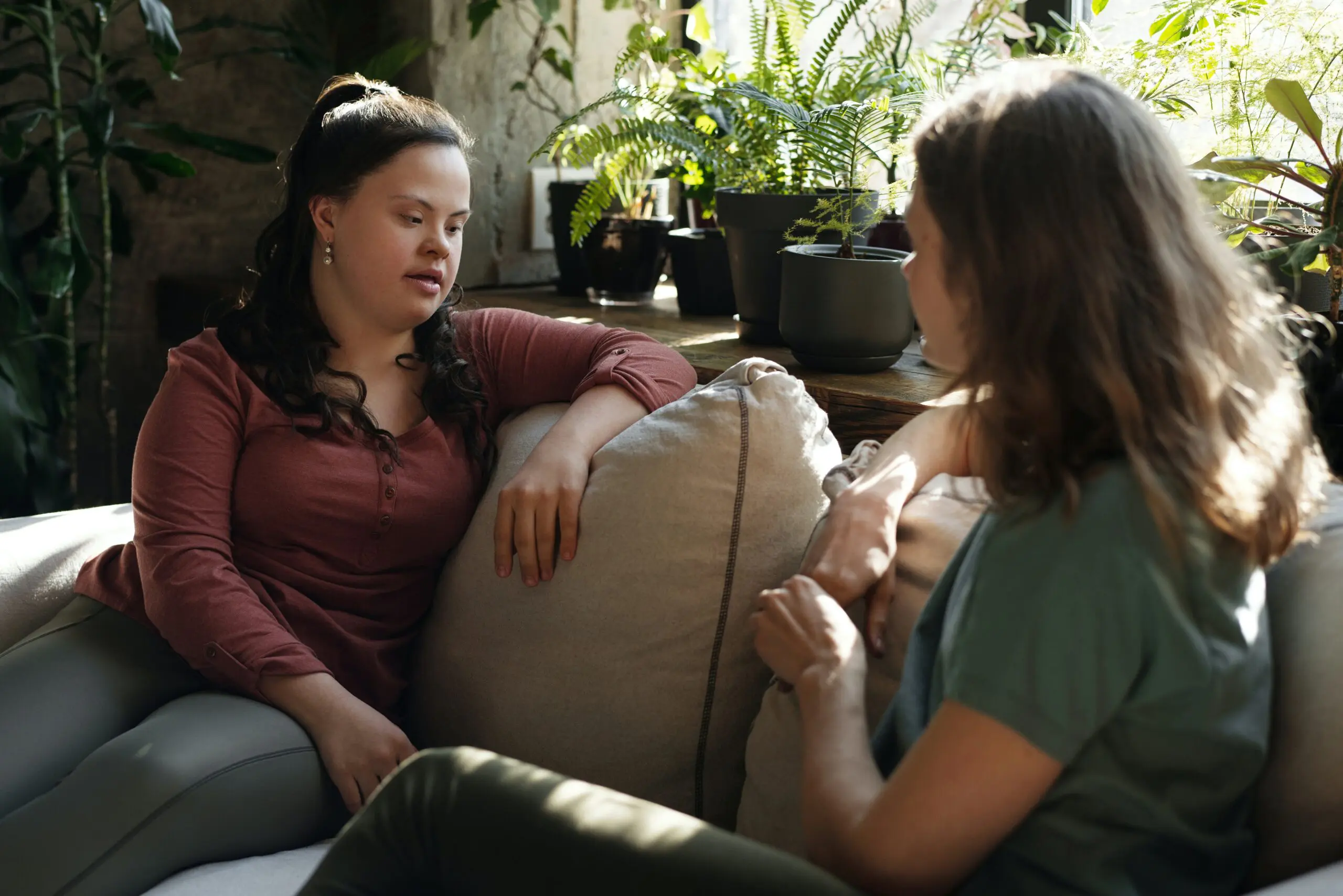 Two people sat on a sofa looking at each other