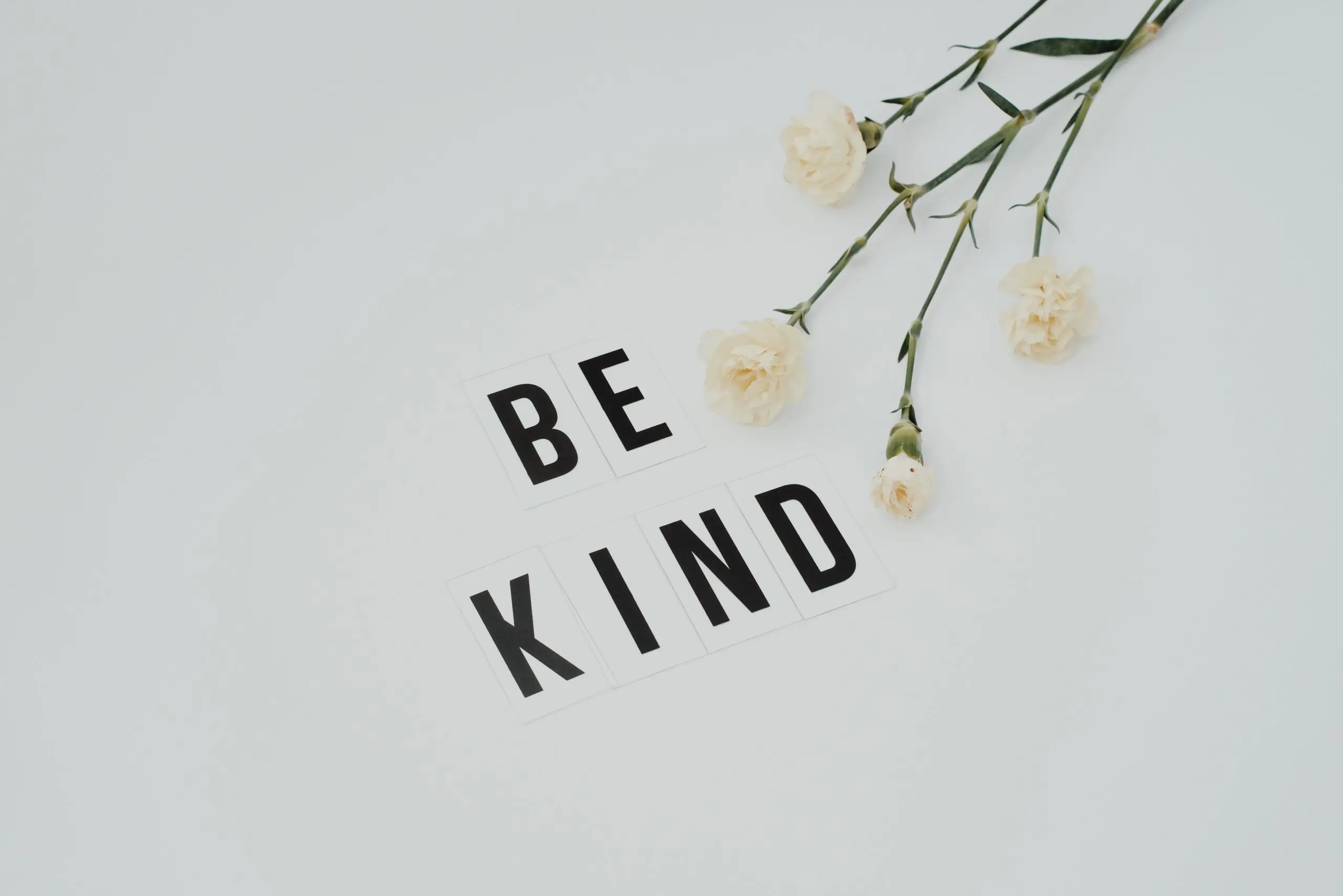 The words 'Be kind' next to a flower