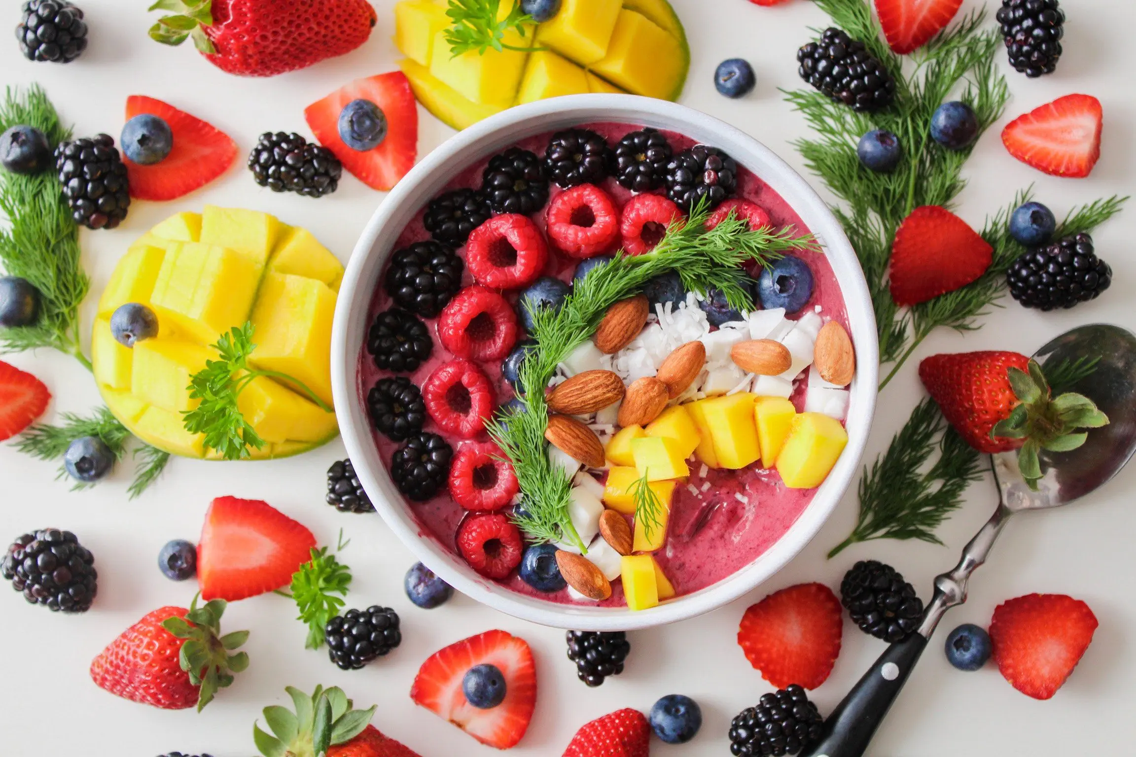 A collection of edible fruit, some of which is in a bowl