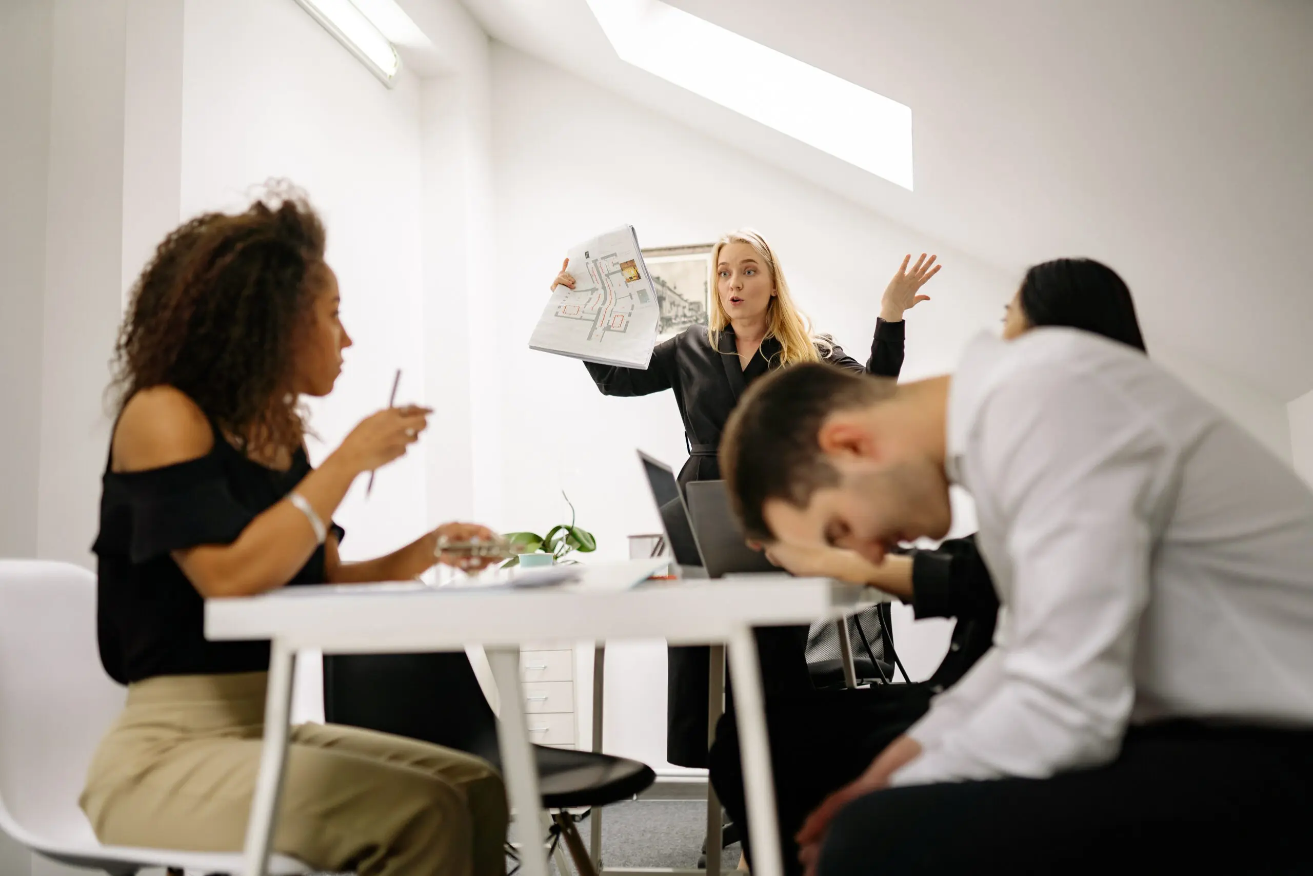 A meeting, with on person being very expressive and one person looking down a their lap