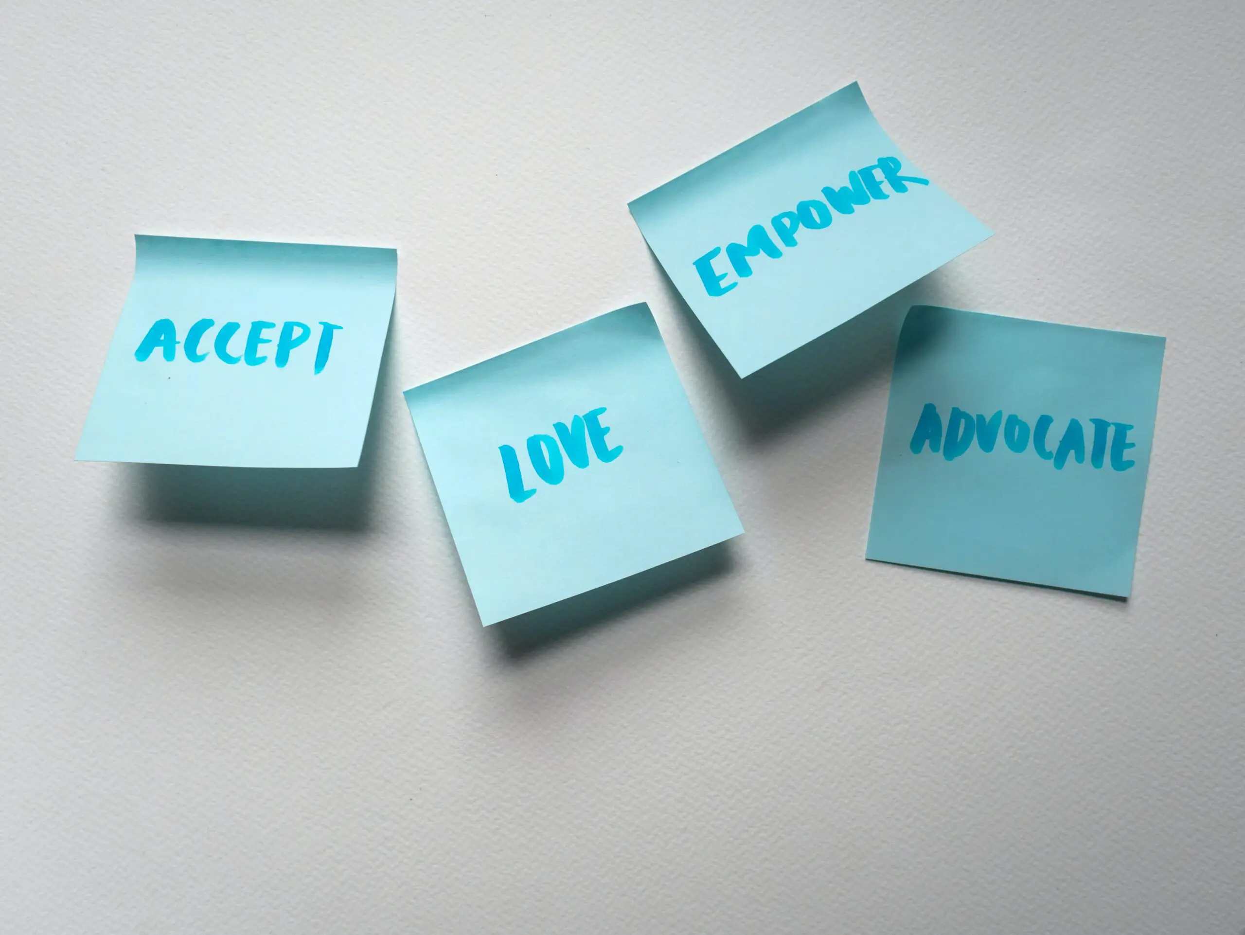 Four post-it notes, with the words 'accept' 'love' 'empower' and 'advocate' on them