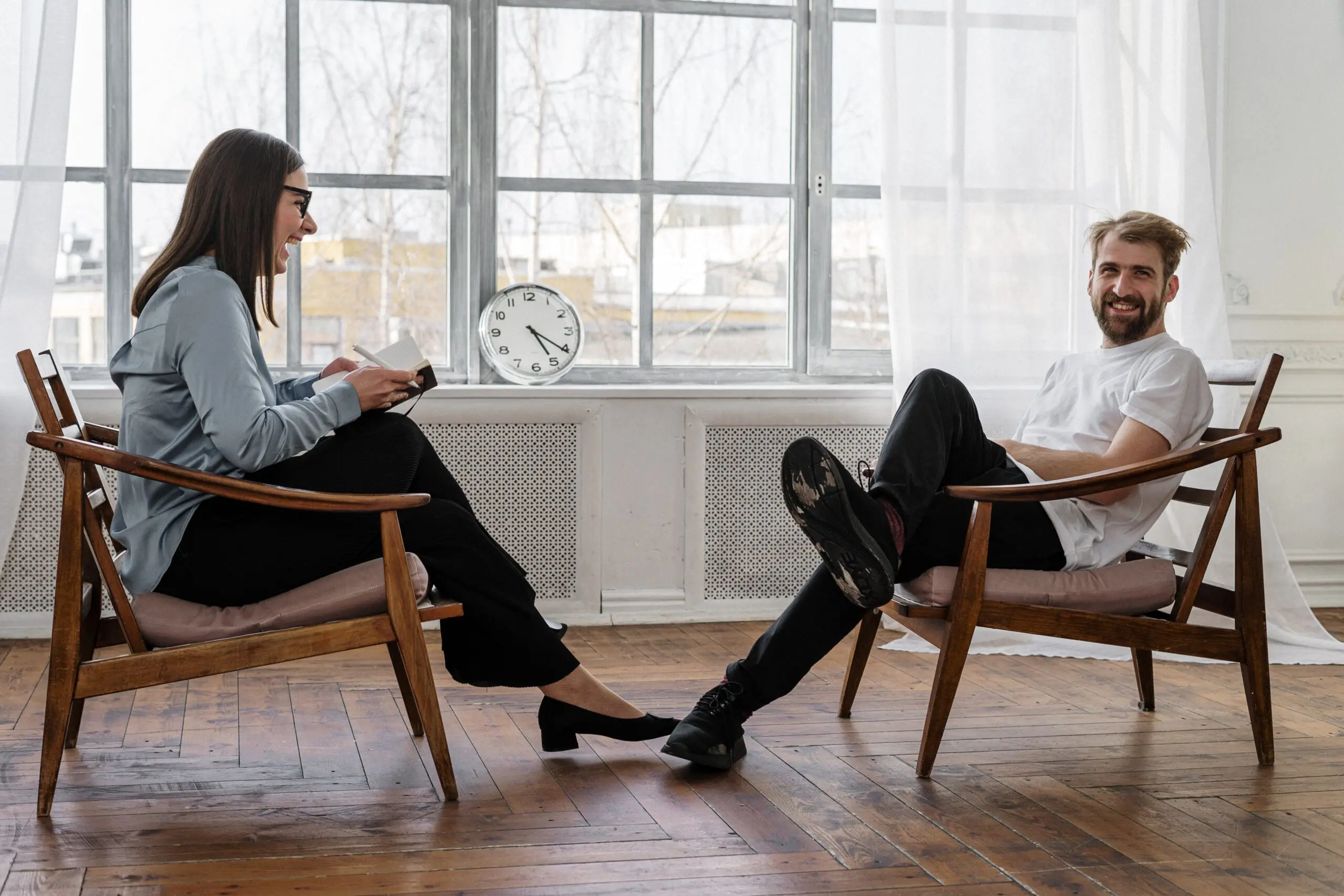 Two laughing people sat opposite each other