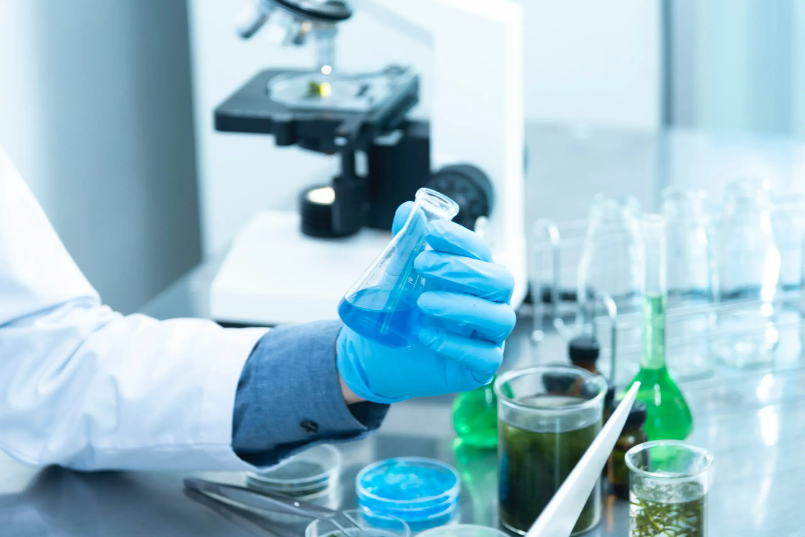Image of someone holding a flask in a lab