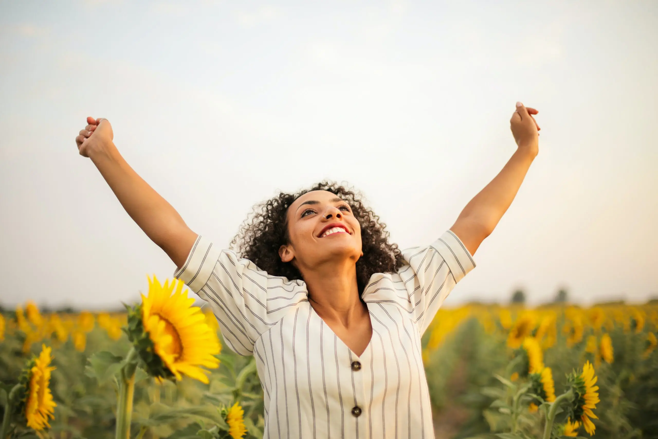 A woman stretching in a field of sunflowers