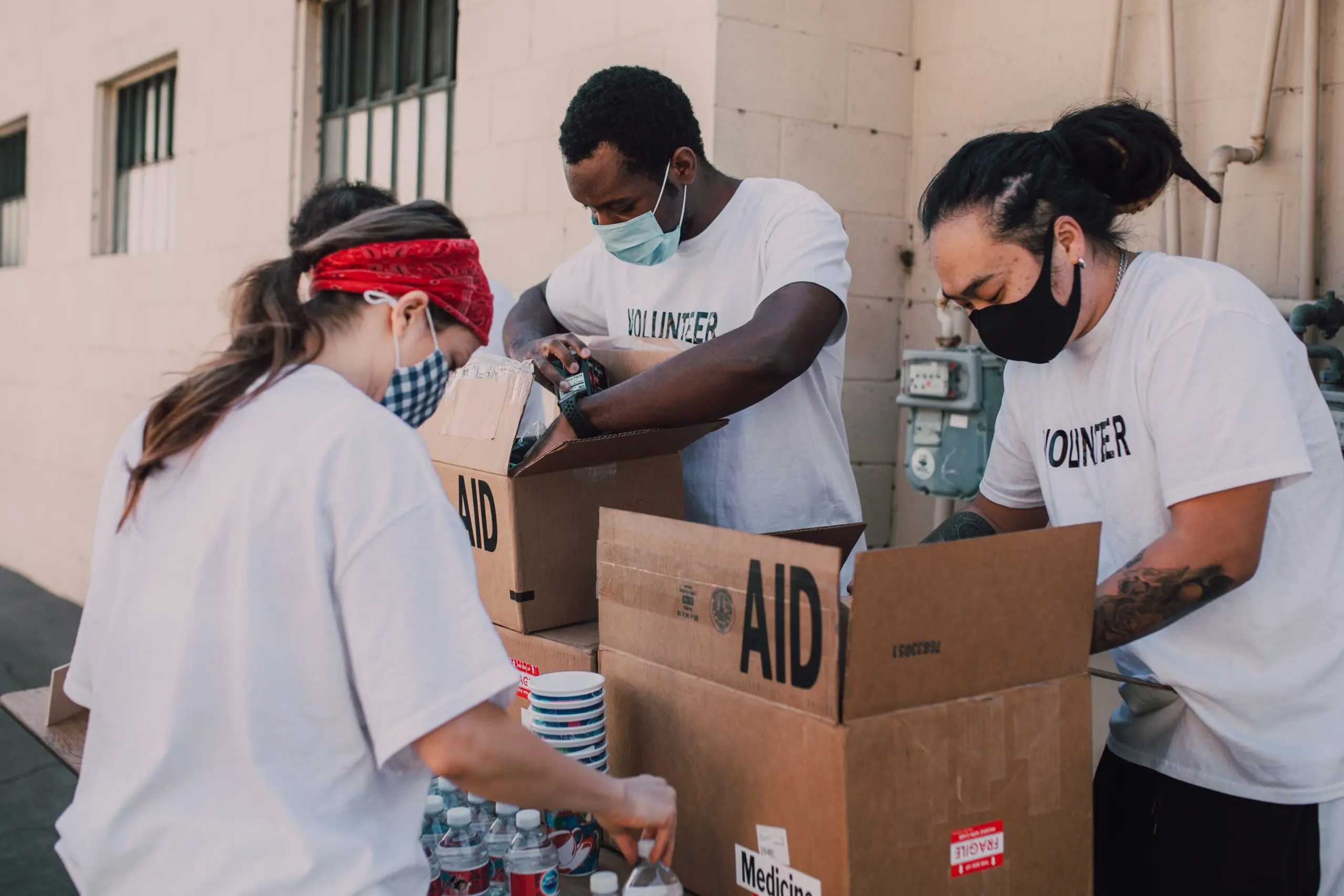 People in volunteer t-shirts unloading water from Aid boxes