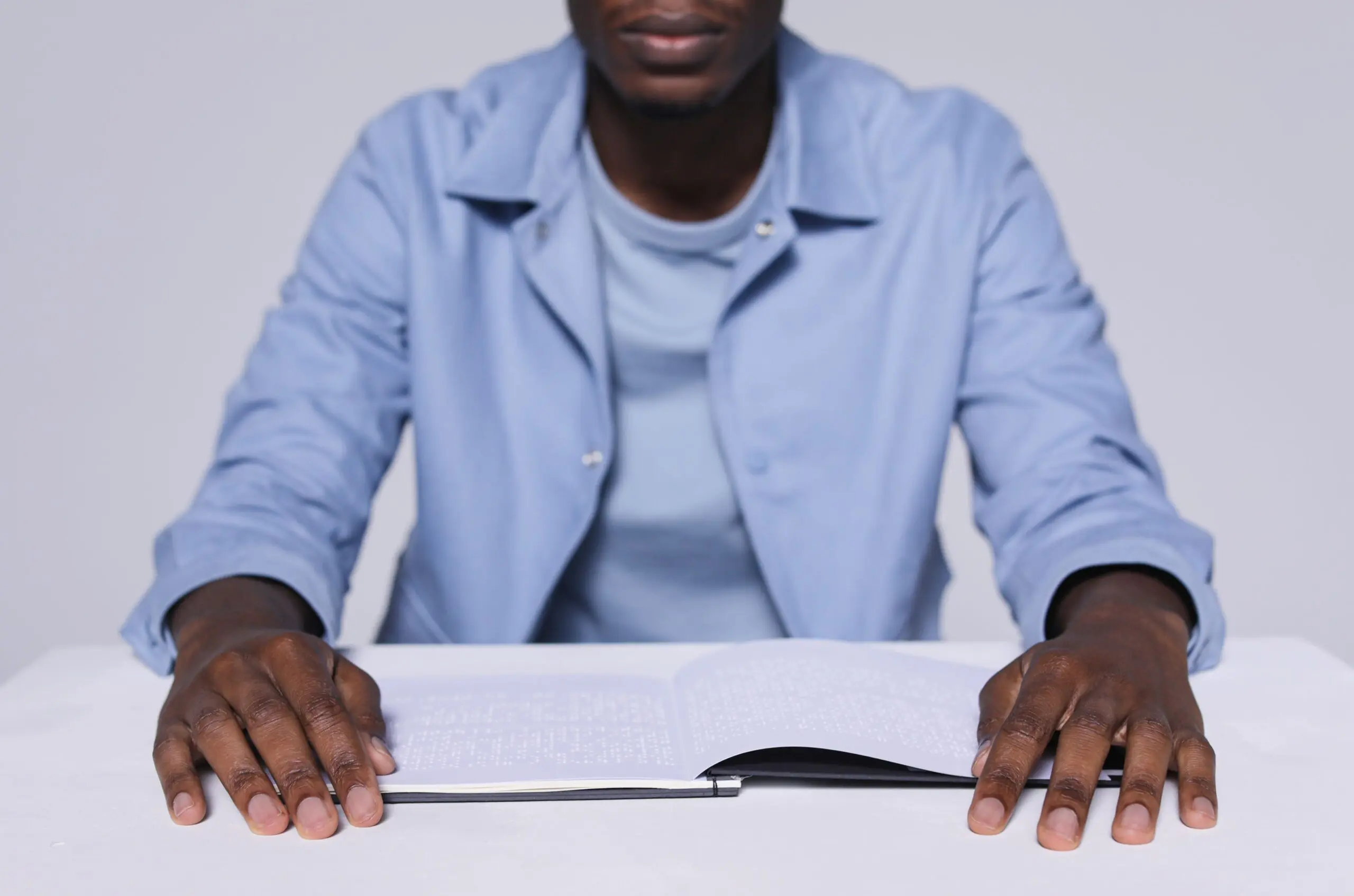 Someone with an open book in Braille in front of them