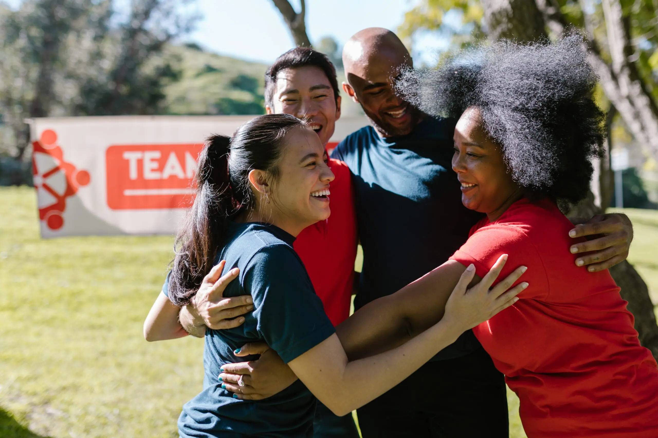 Four people smiling and hugging