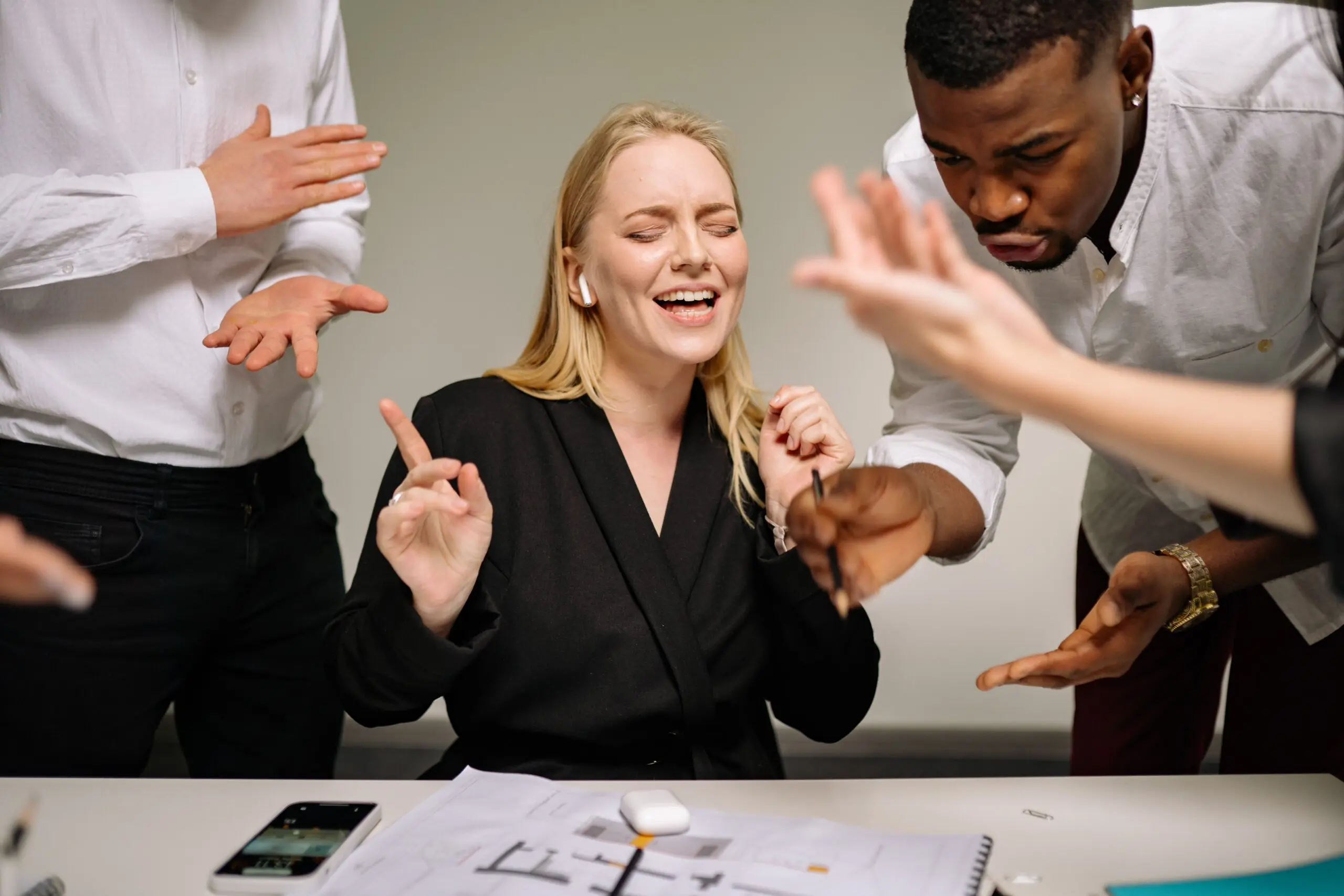 Three people shouting at someone laughing while listening to music