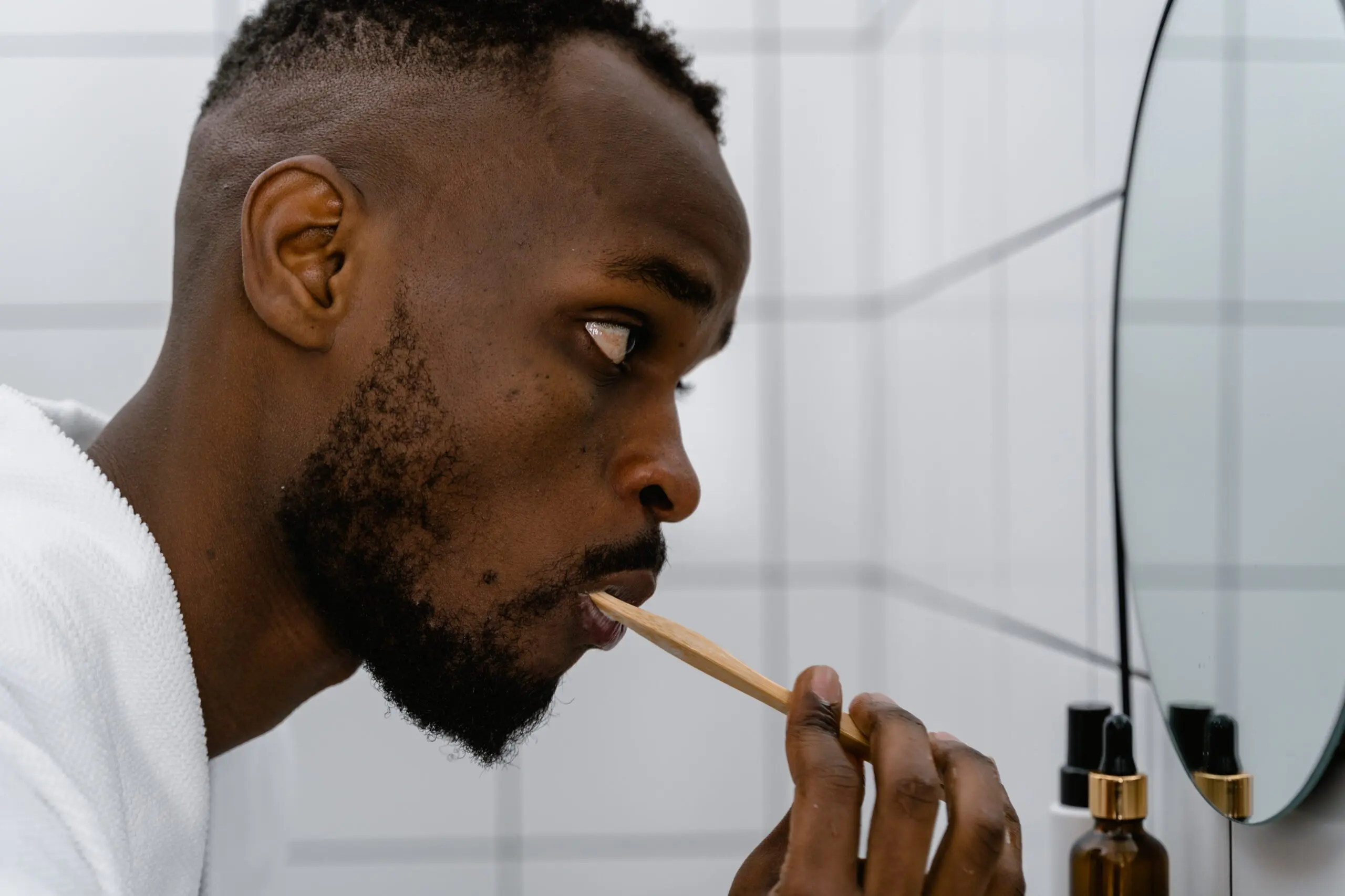 A man brushing his teeth in the mirror