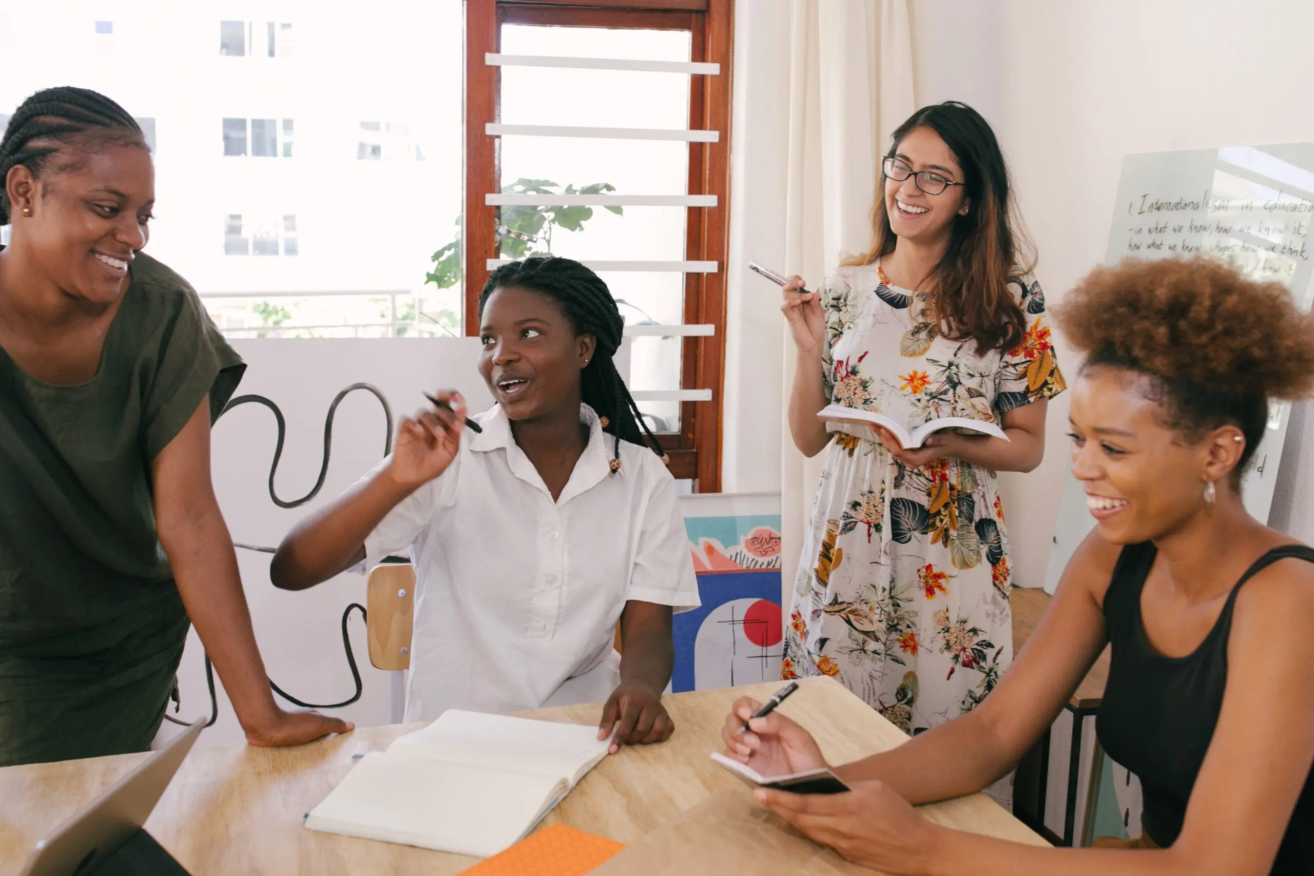 Four people laughing together around a table