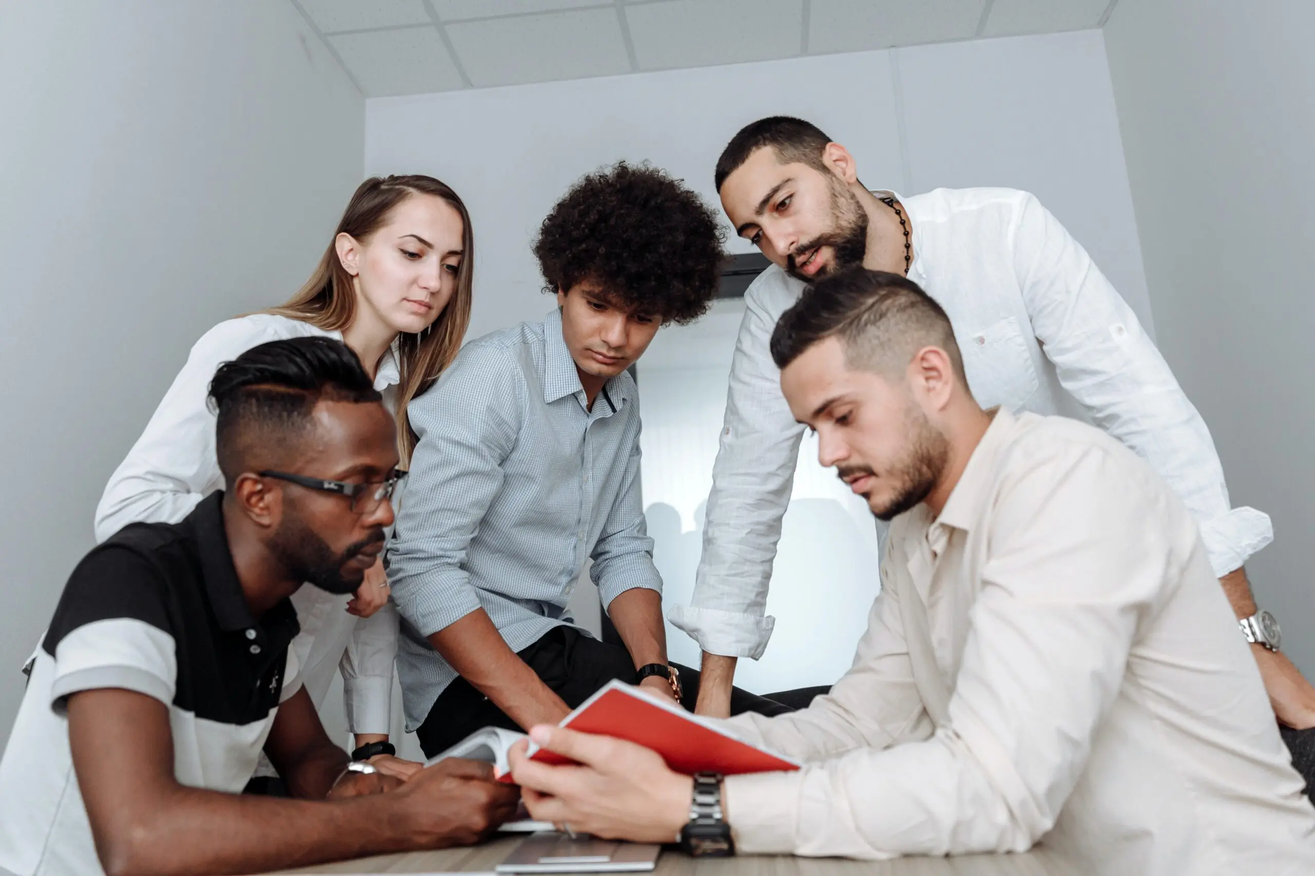 Five people looking down at the same book