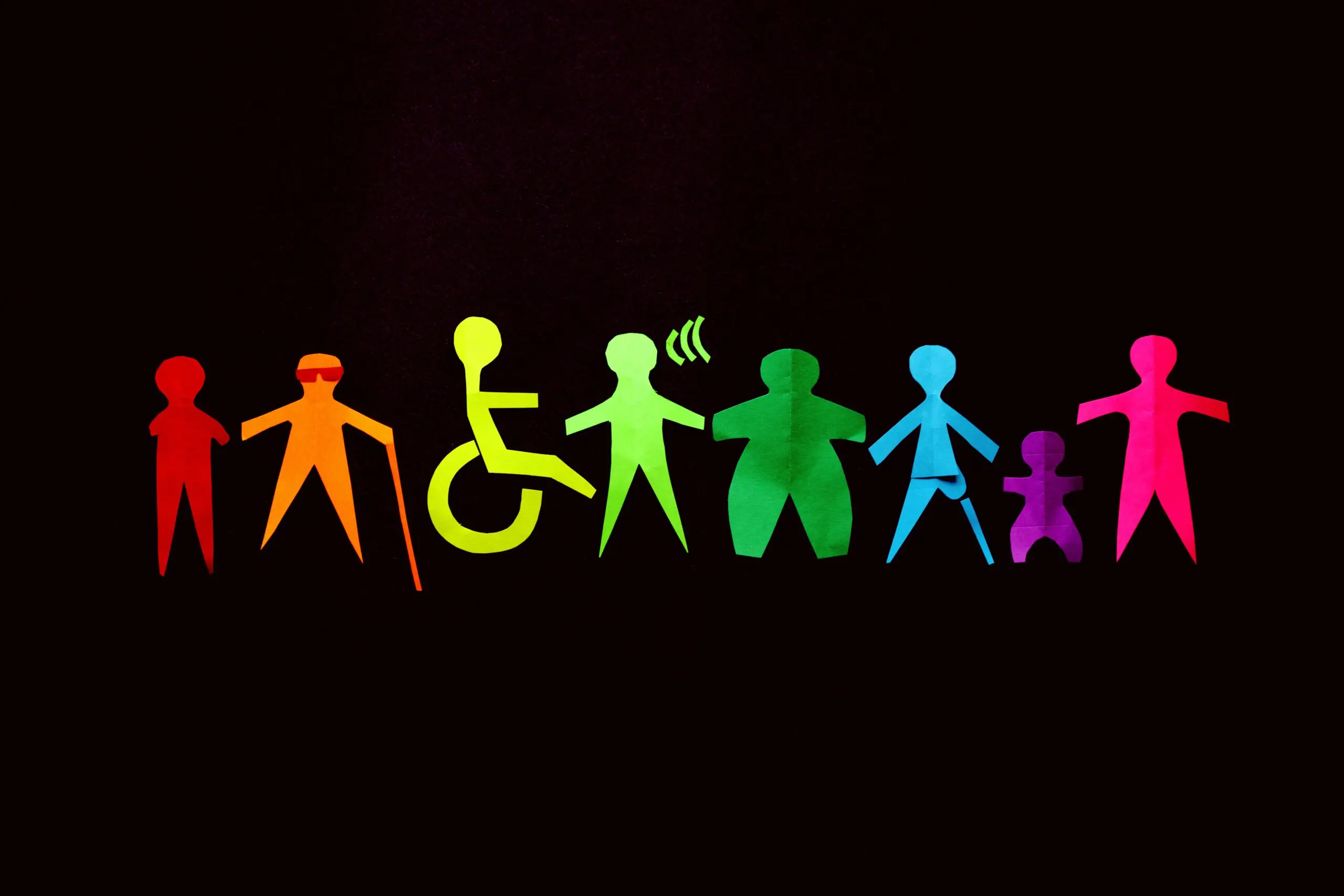 A collection of eight stylised people, with different disabilities, each a different colour of the rainbow