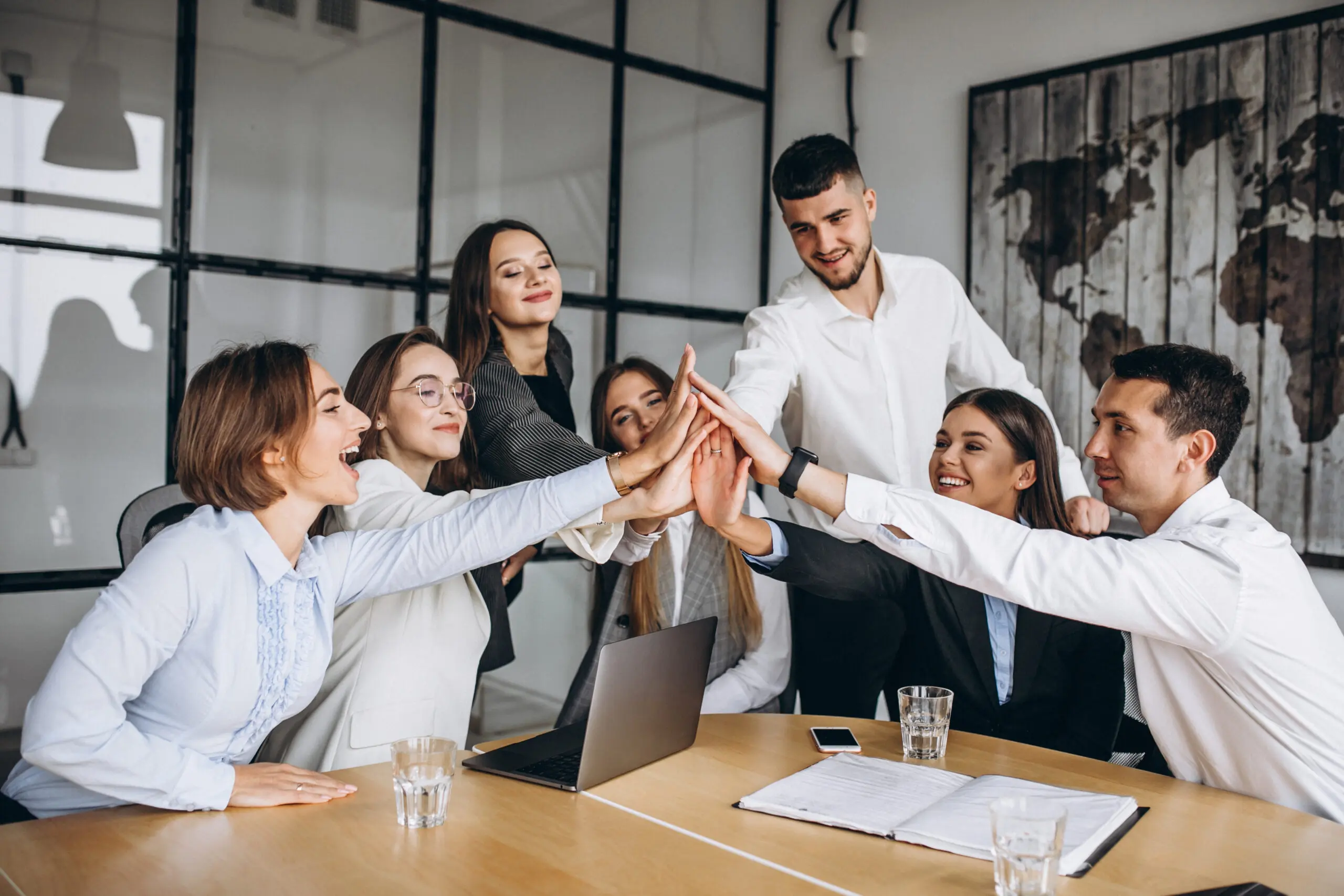 A group of people communicating at work and all high-fiving