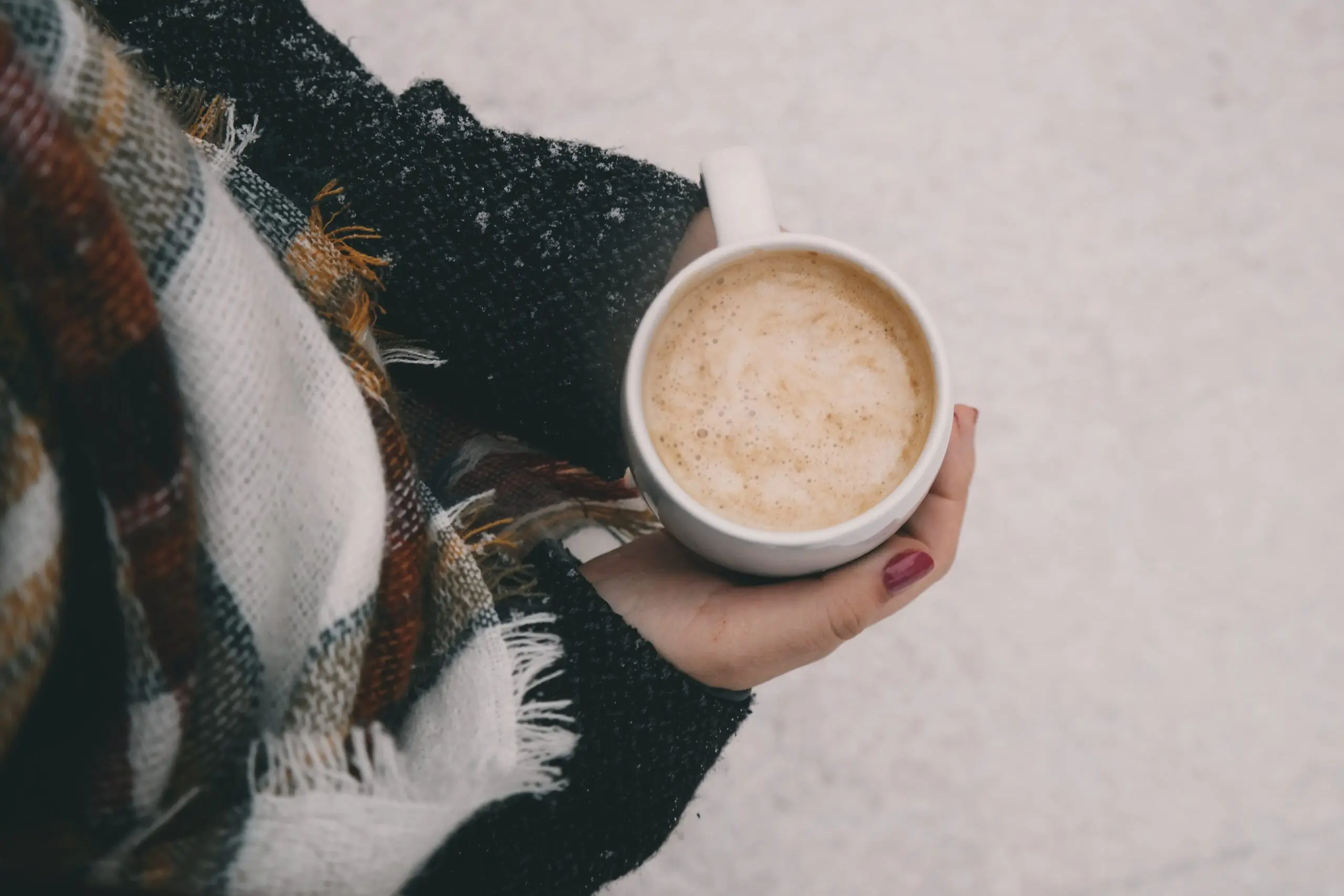woman-enjoying-a-warm-drink-while-surrounded-by-snow