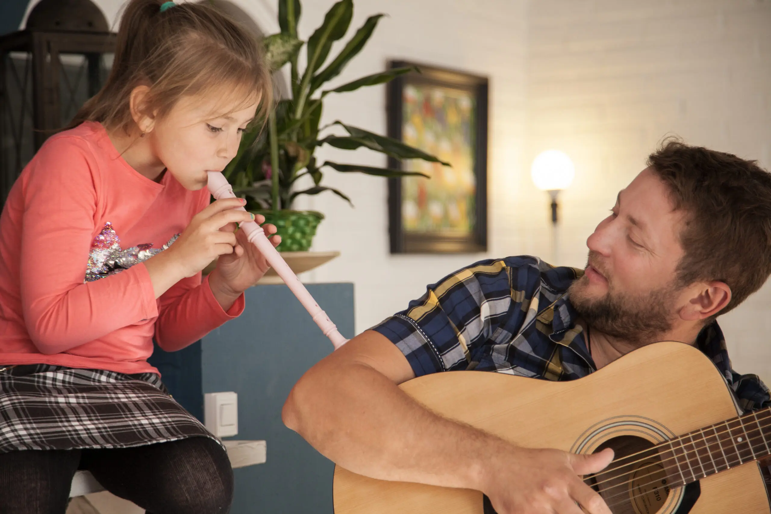 caregiver-supporting-a-little-girl-through-music-therapy