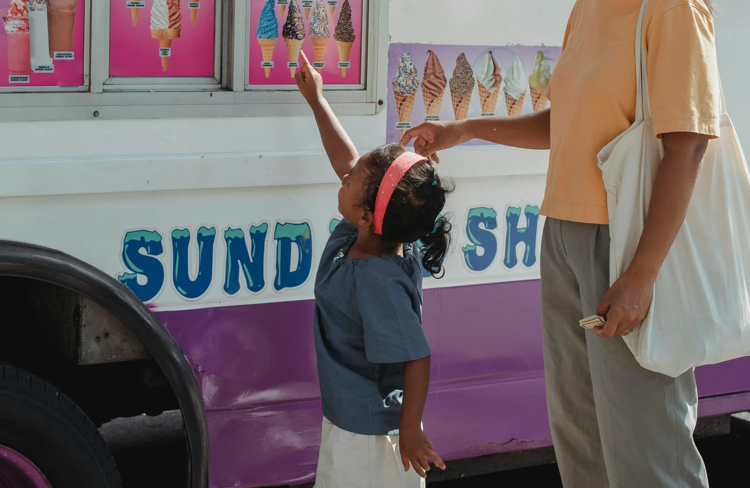 little-girl-with-her-mum-pointing-to-the-icecream-she-wants-on-the-icecream-truck