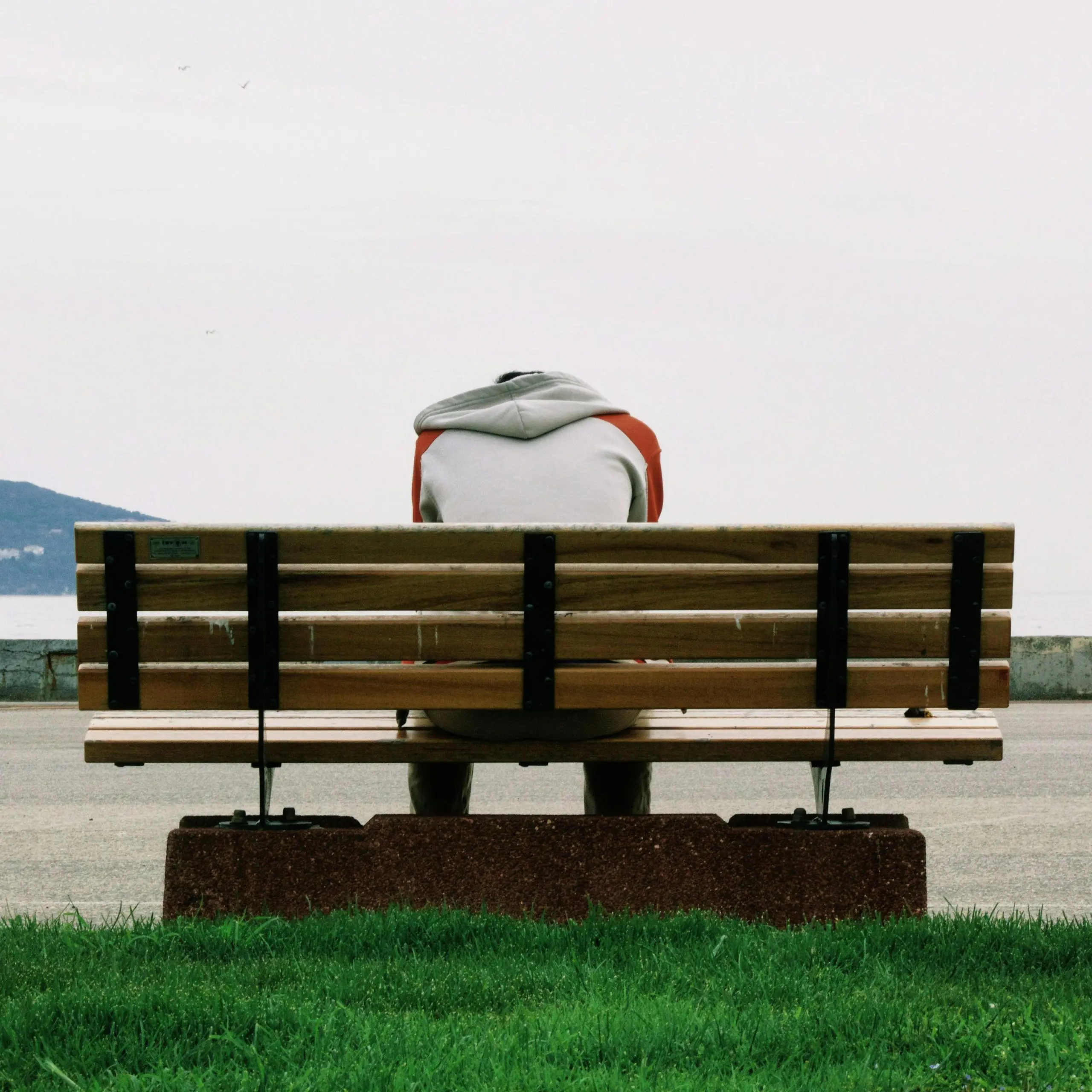man-hunched-over-on-bench
