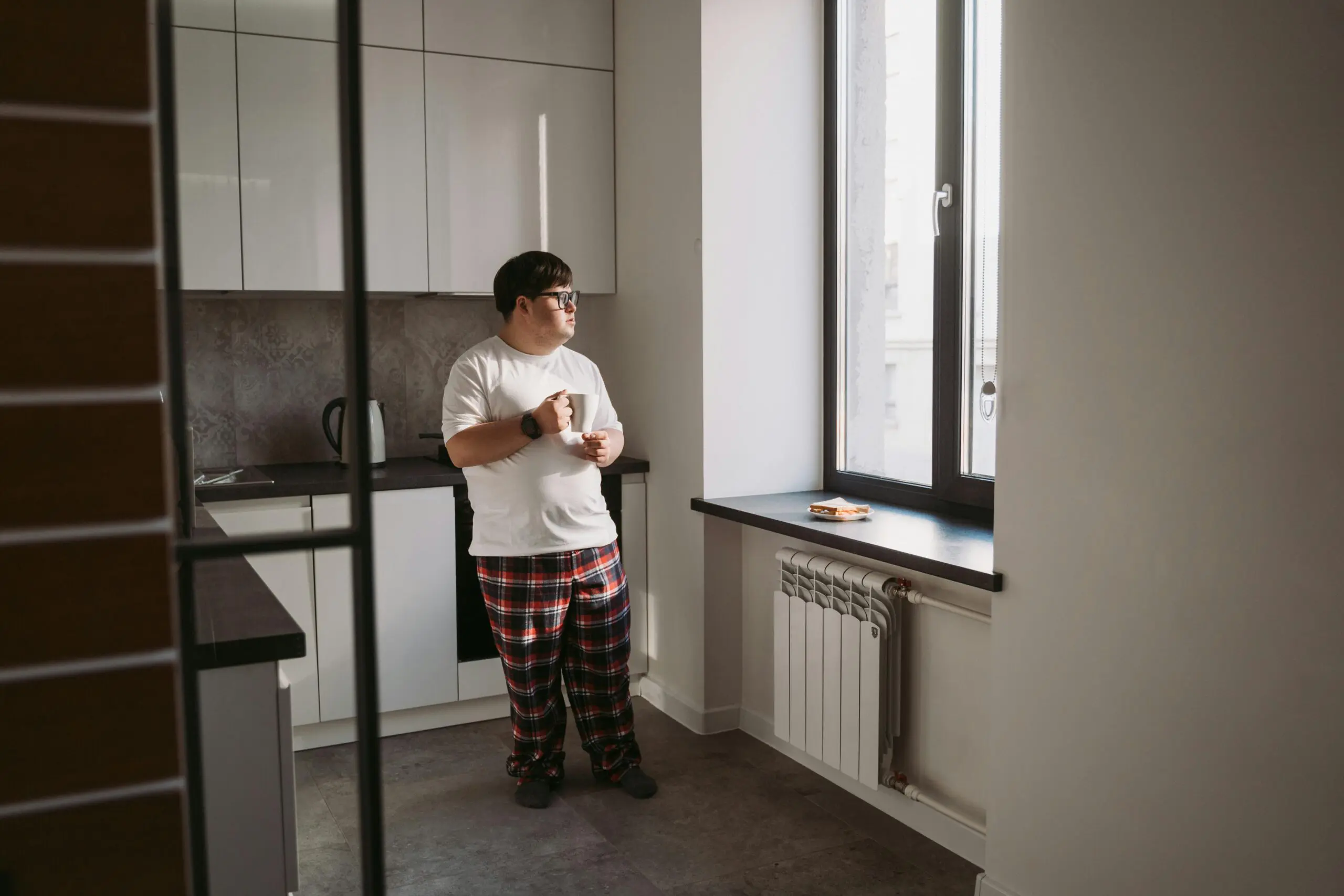 man with down syndrome looking out window
