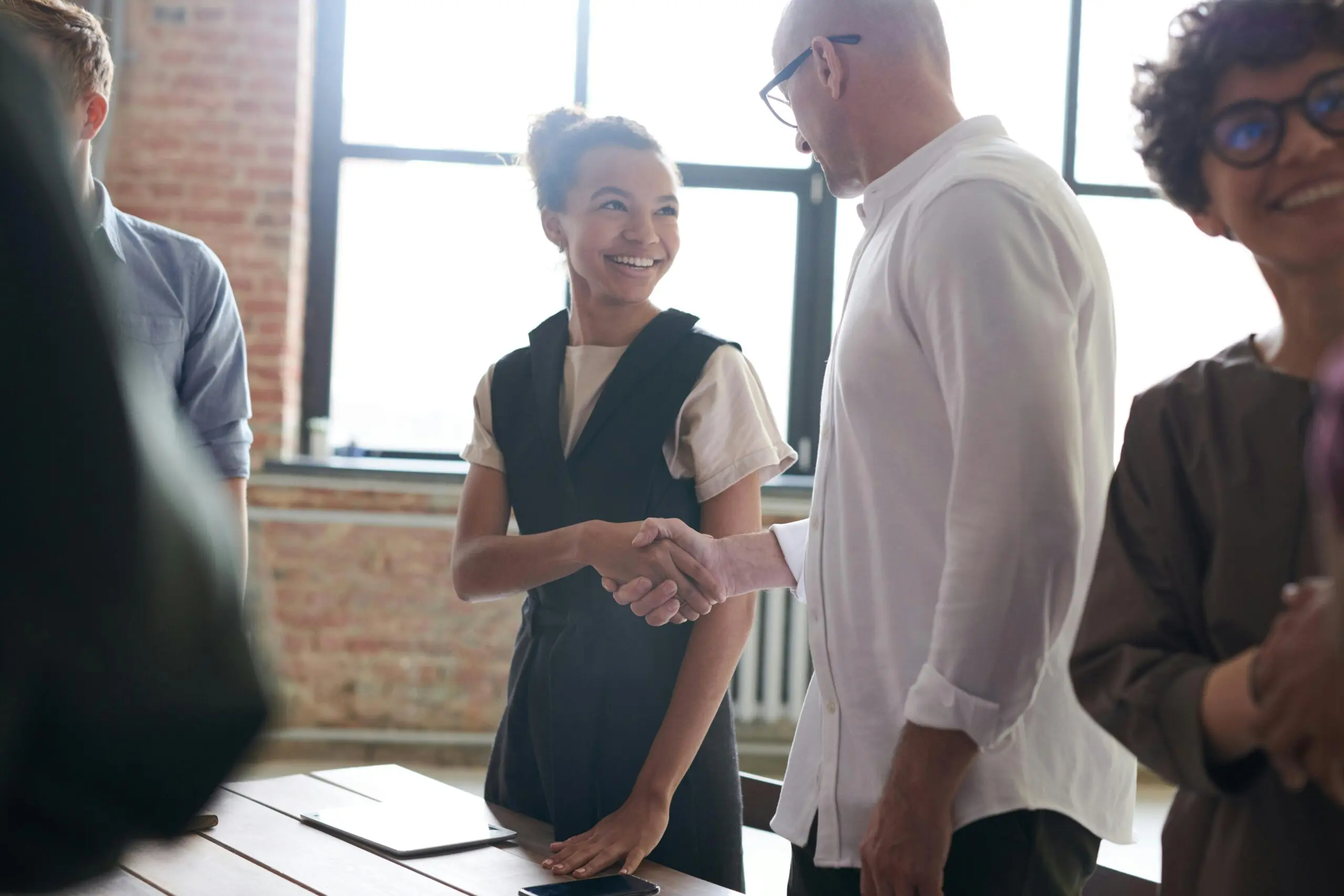woman-and-man-shaking-hands-while-smiling