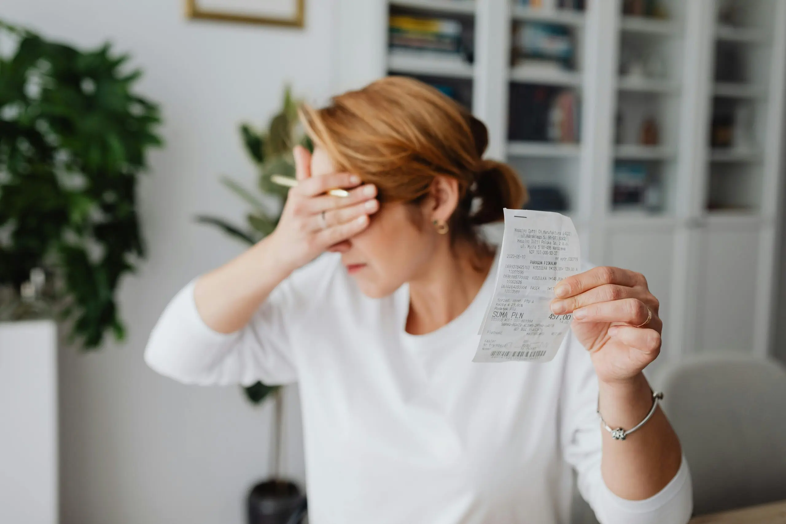 woman-covering-eyes-while-looking-at-food-receipt