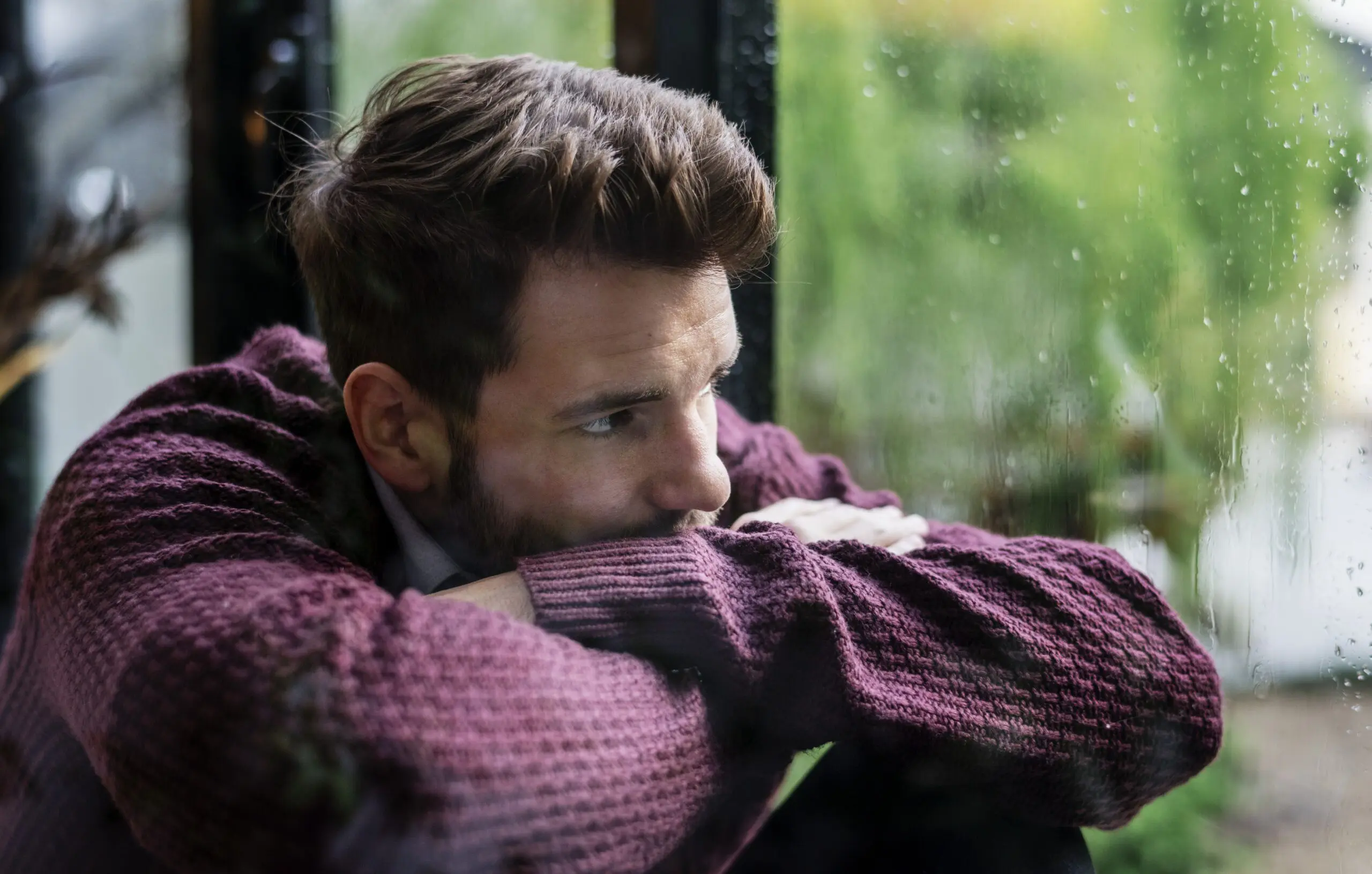 man-sadly-looking-out-of-window