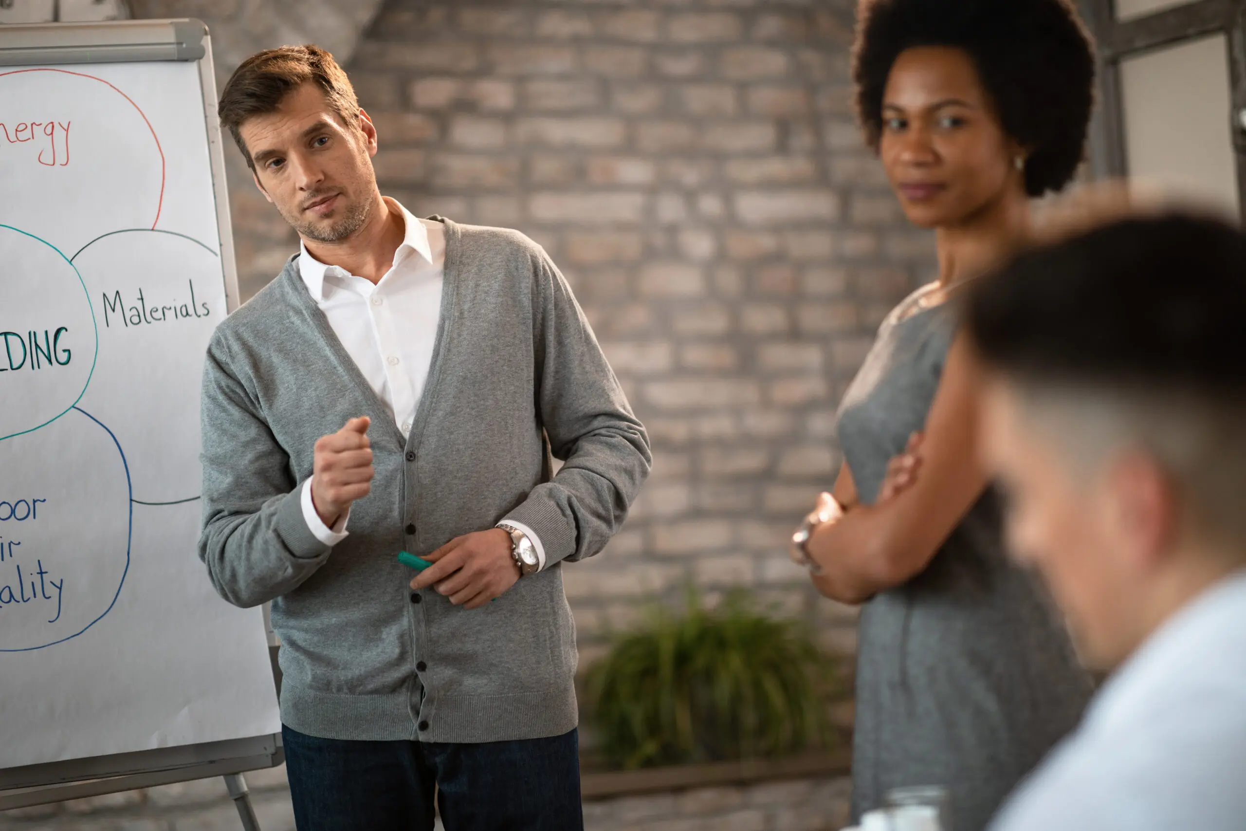 team-members-attending-a-training-session-together-with-trainer-using-a-presentation-to-showcase-skills-they-will-need-to-learn