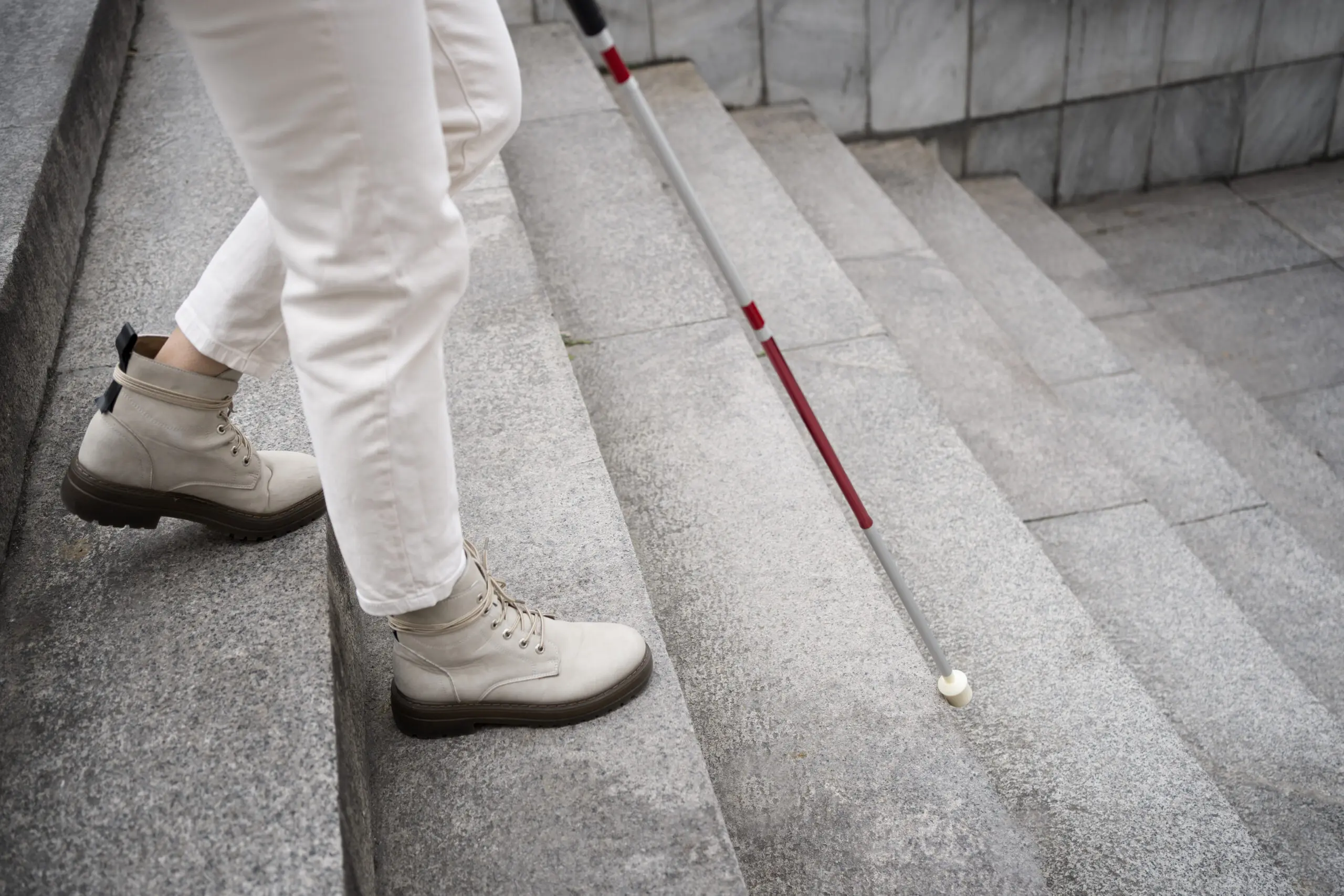 blind woman walking down the stairs into the workplace using her cane