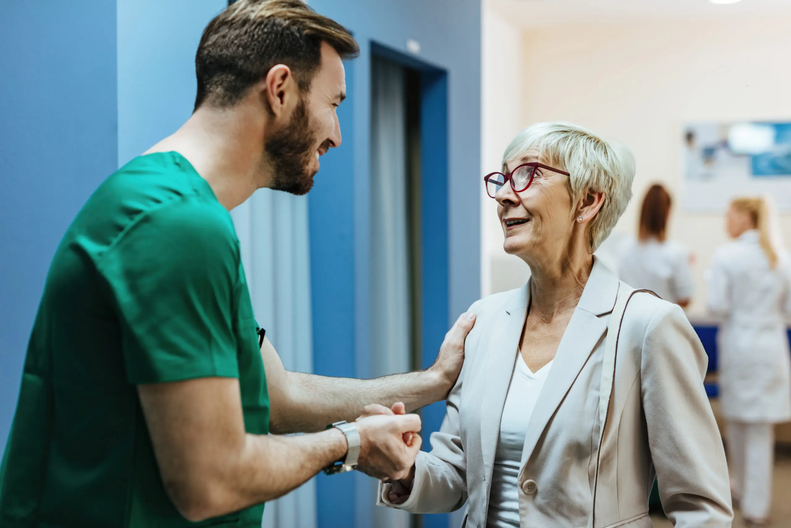 new smiling, happy support worker greeting the woman who he supports