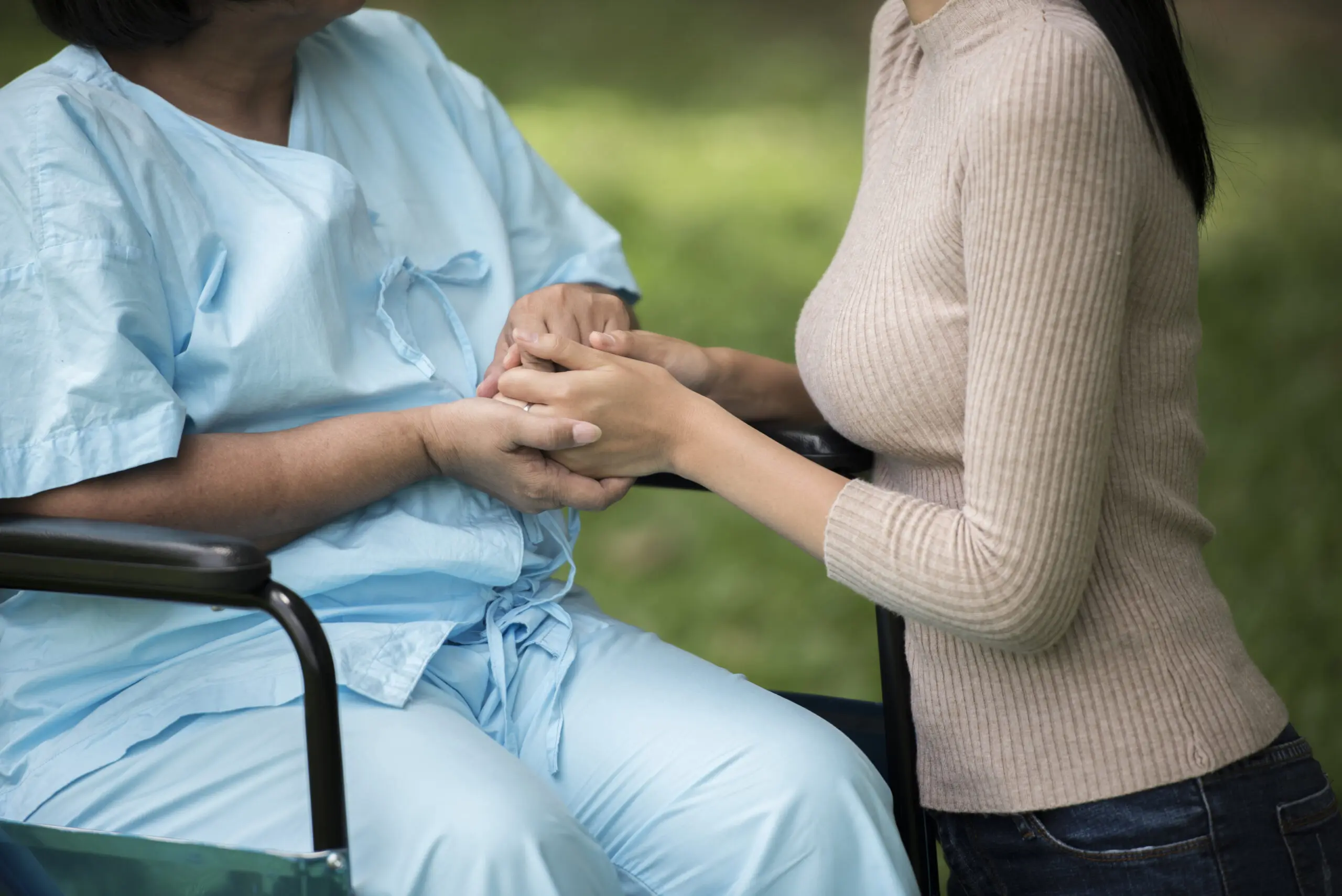 Support worker and patient holding hands to show support