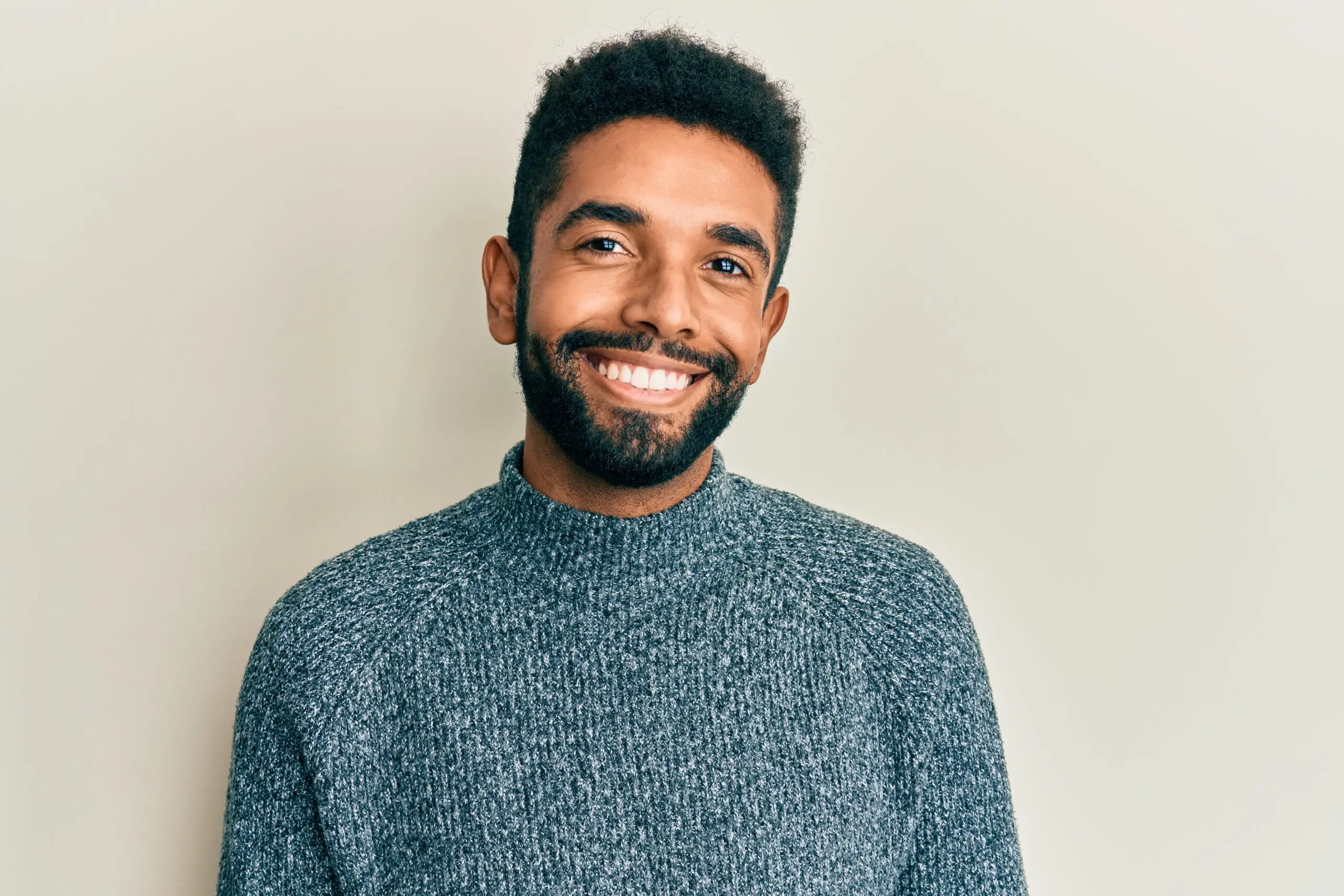 Hispanic autistic man with beard smiling at the camera