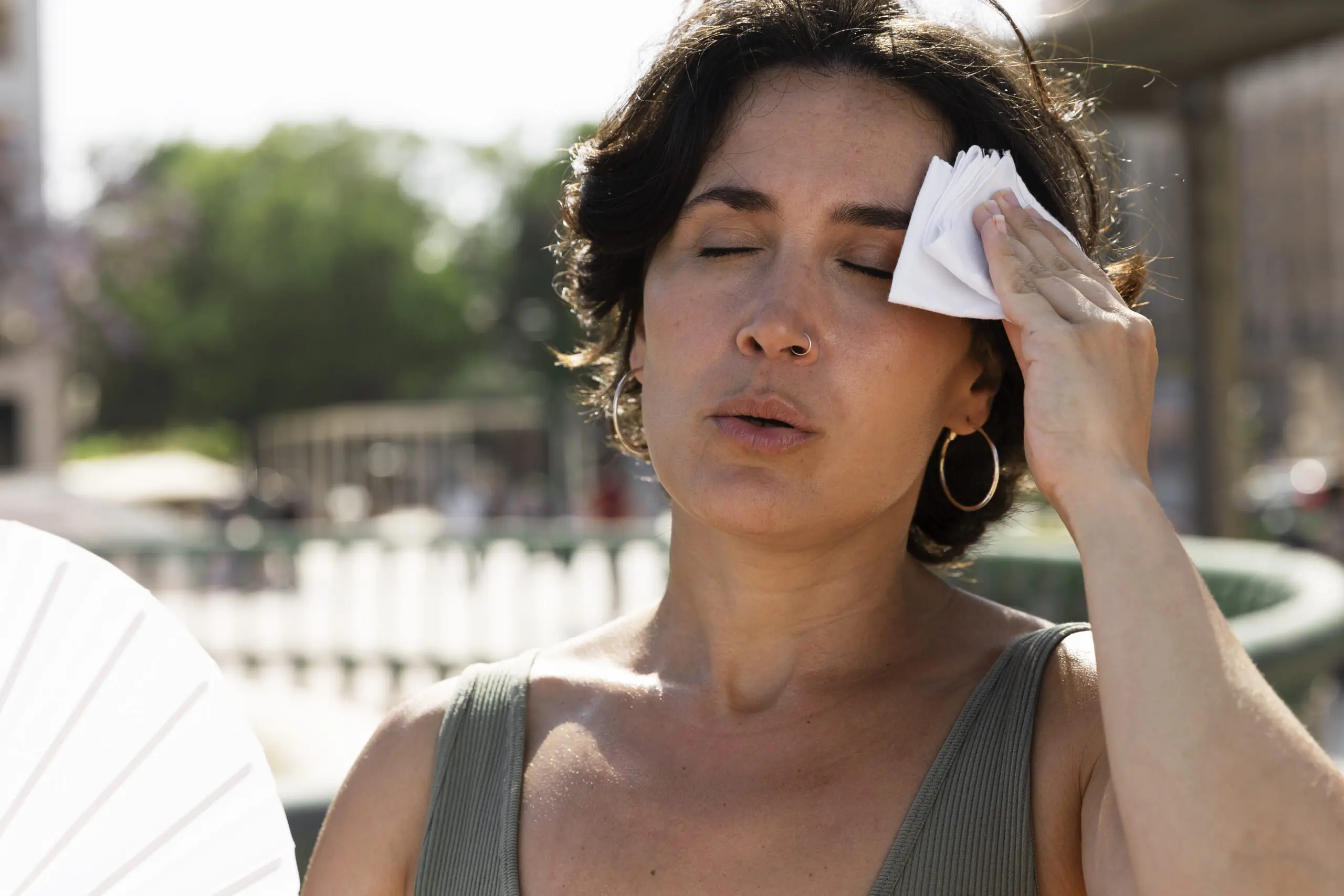 woman who is feeling warm and ill in increasing hot weather in the uk