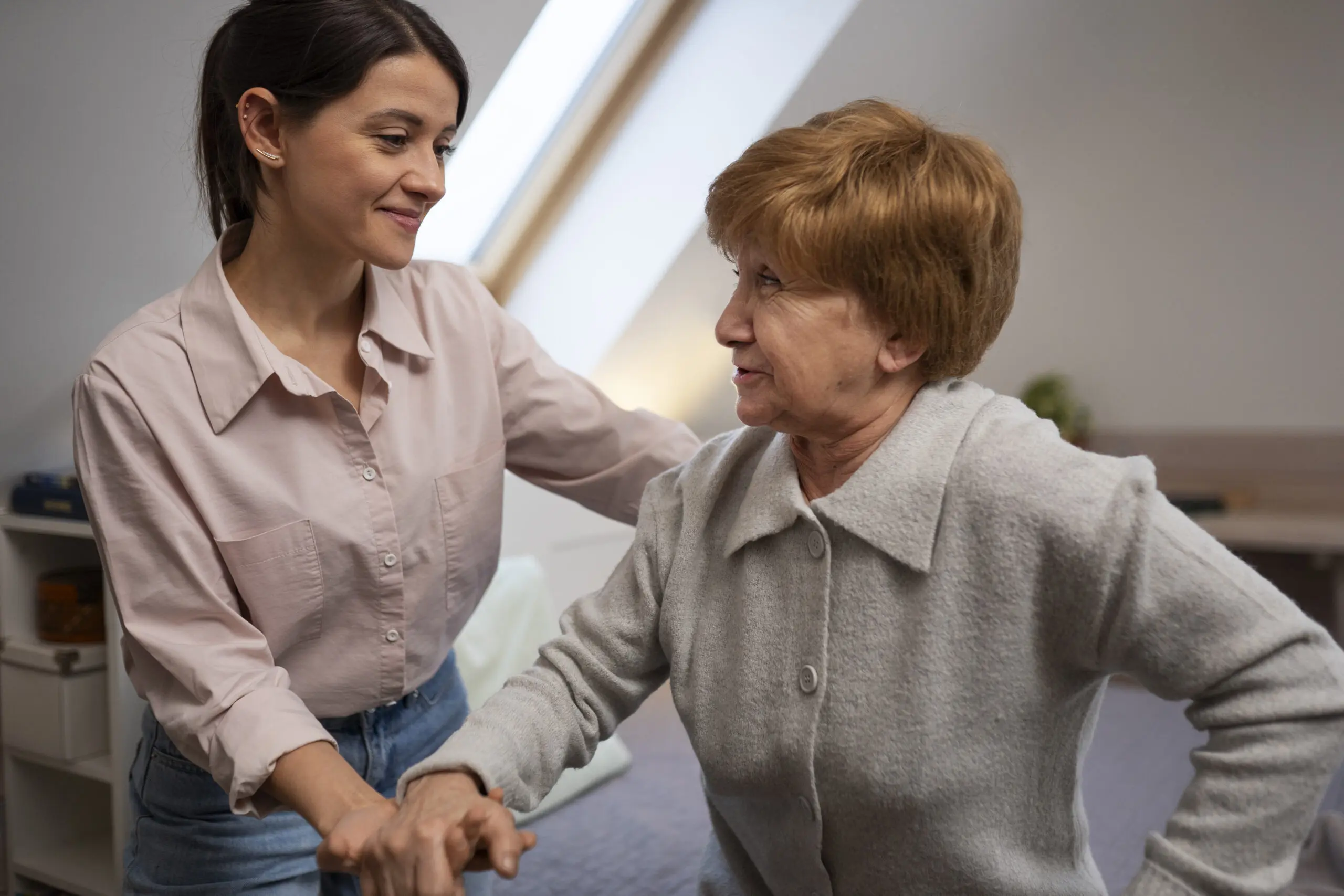support worker and elderly patient smiling at each other