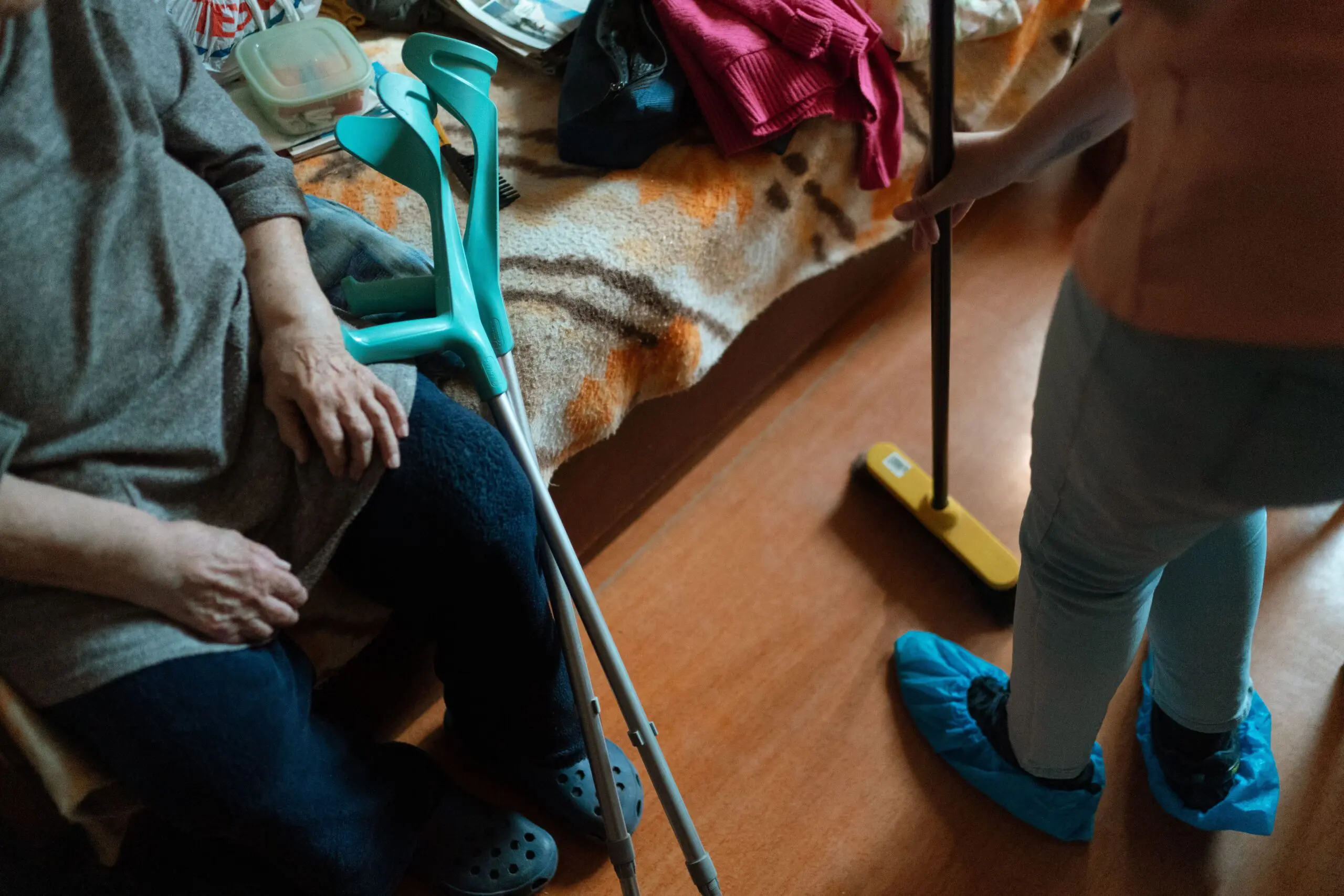 care worker cleaning the floor of a care home room