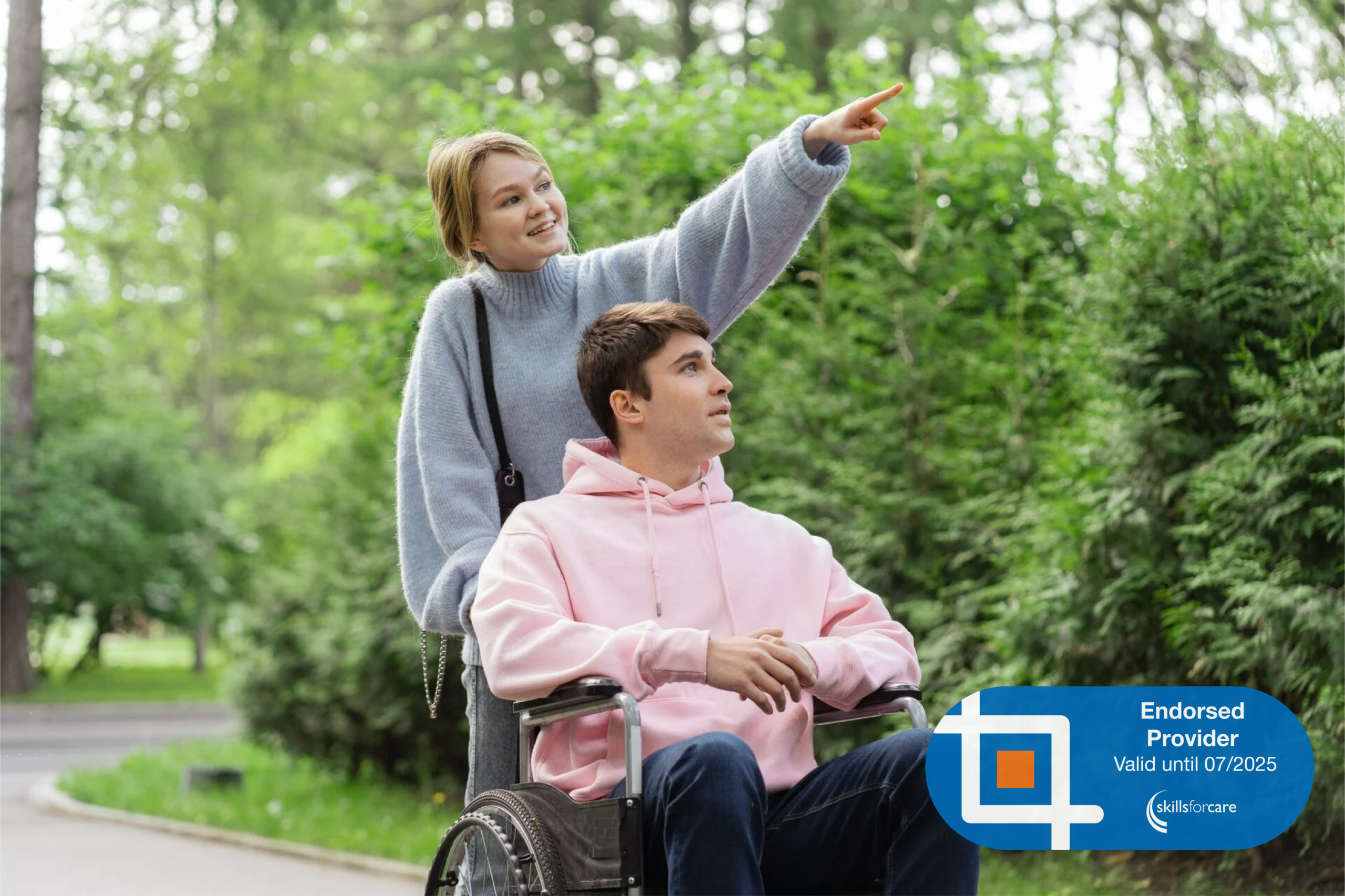 A smiling woman pointing something out to someone in a wheelchair. At the bottom right corner is the Skills For Care Endorsed Provider logo